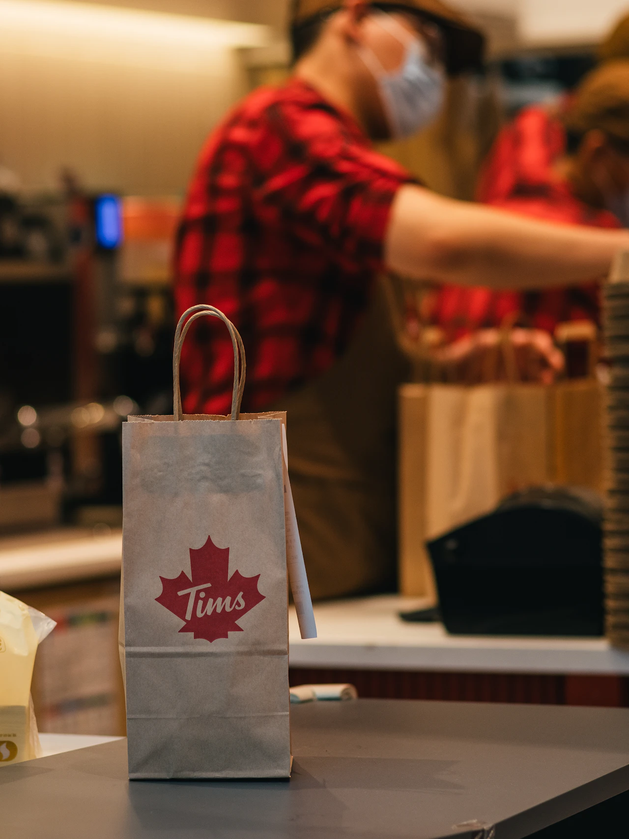 A staff member at the counter with a packed order, where an online sale finally closes in person