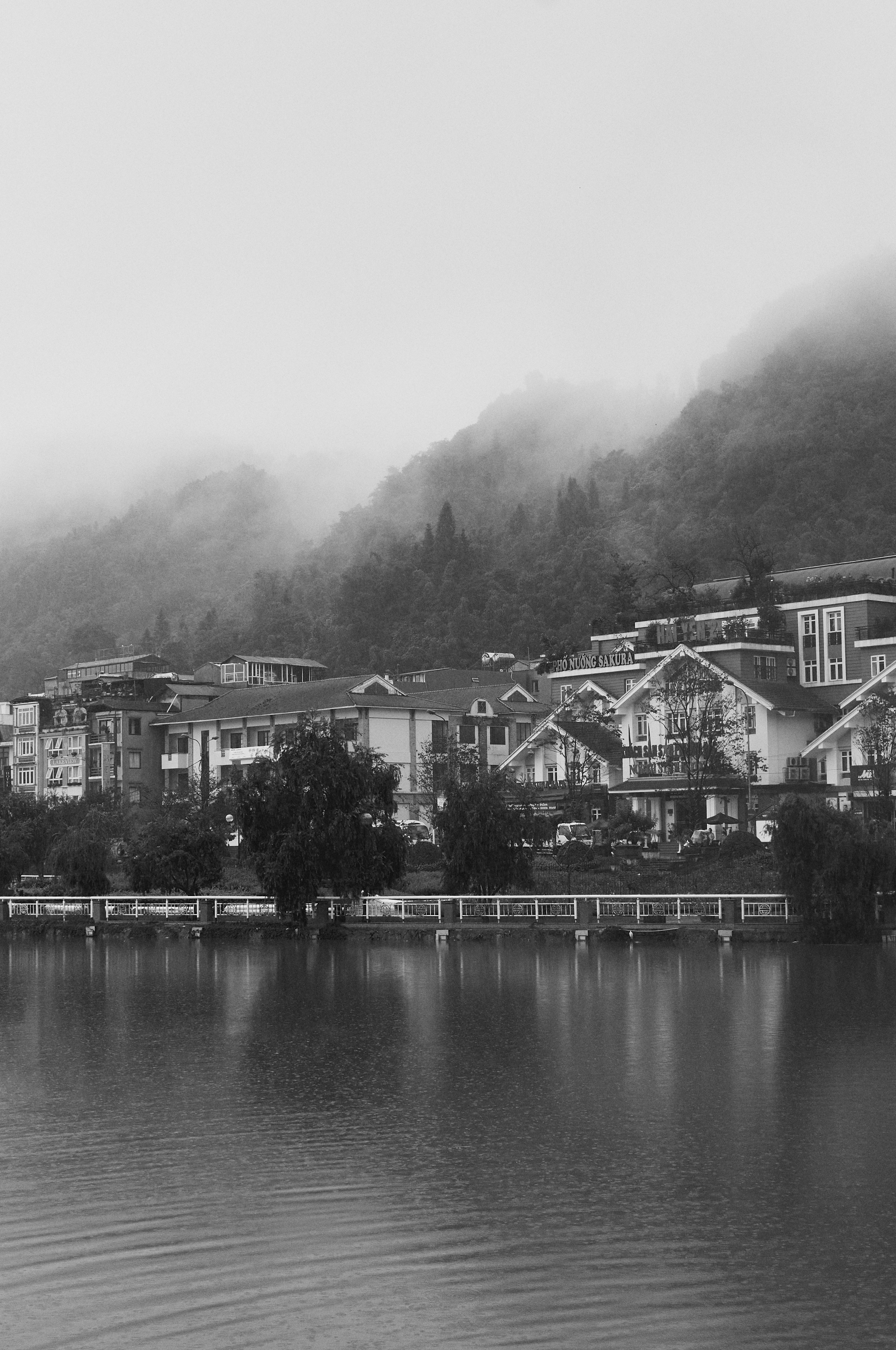 A black and white photo of a town on a lake
