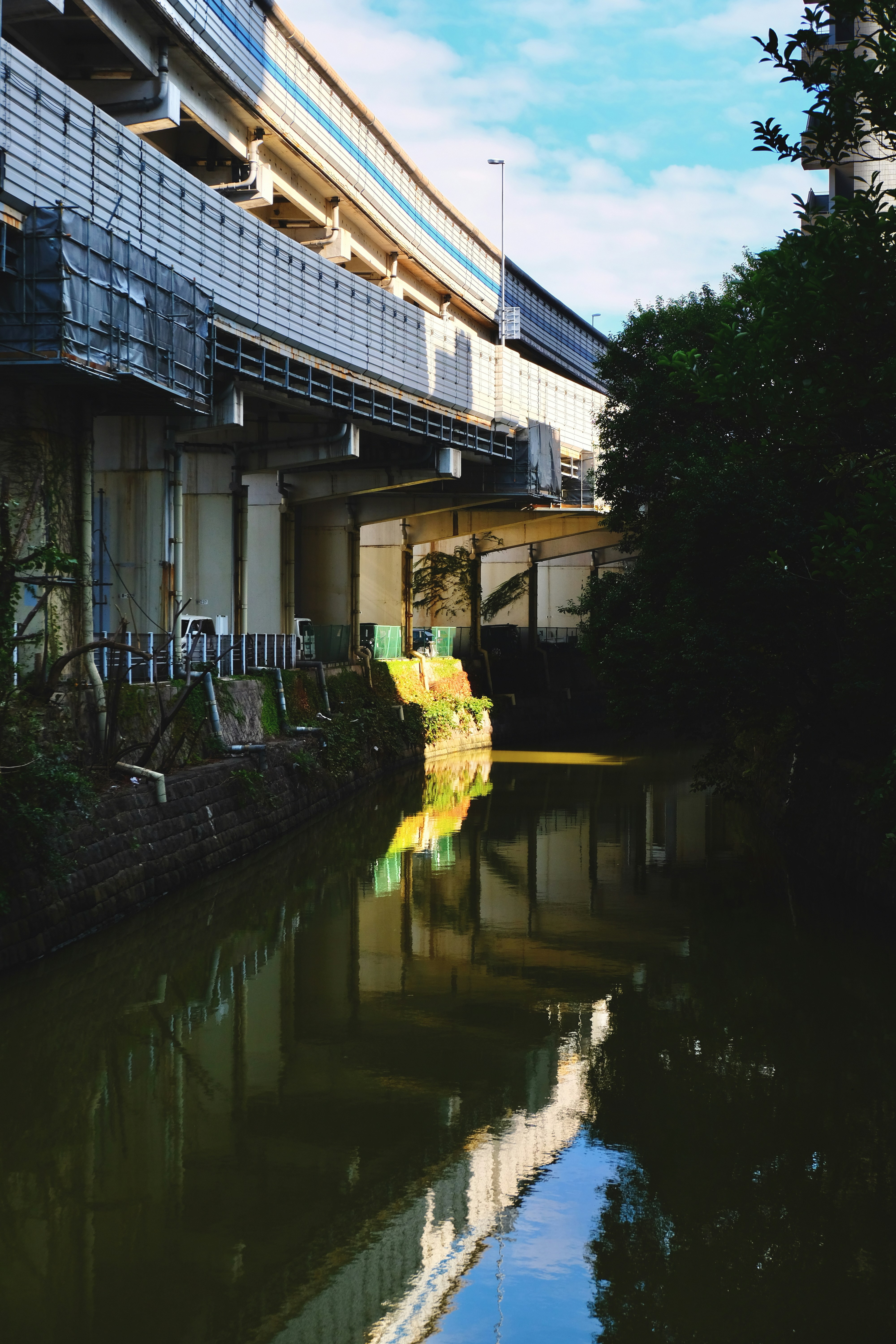 Un río que corre bajo un puente junto a un edificio alto