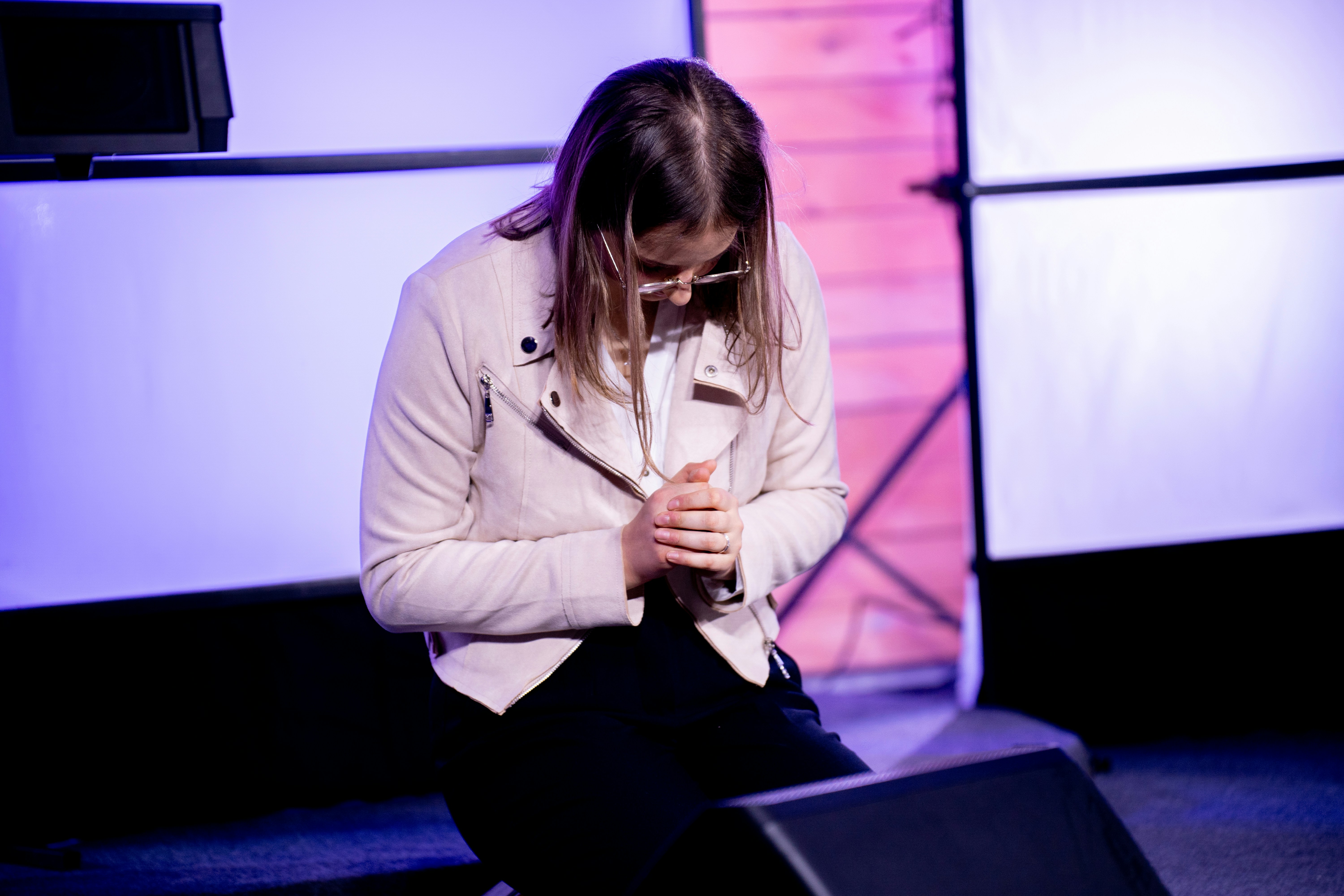 A woman sitting on a chair looking at her cell phone