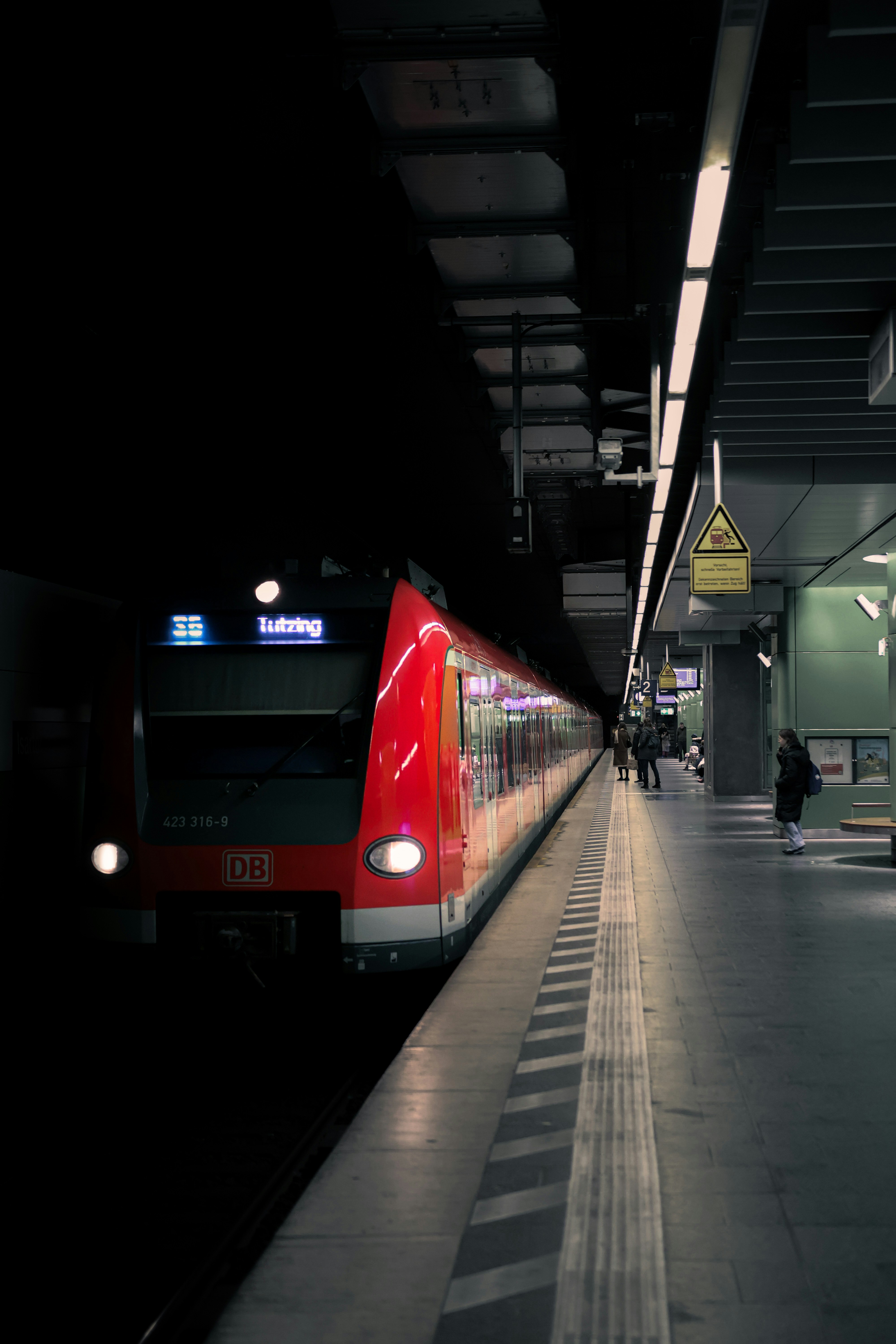 A red train pulling into a train station