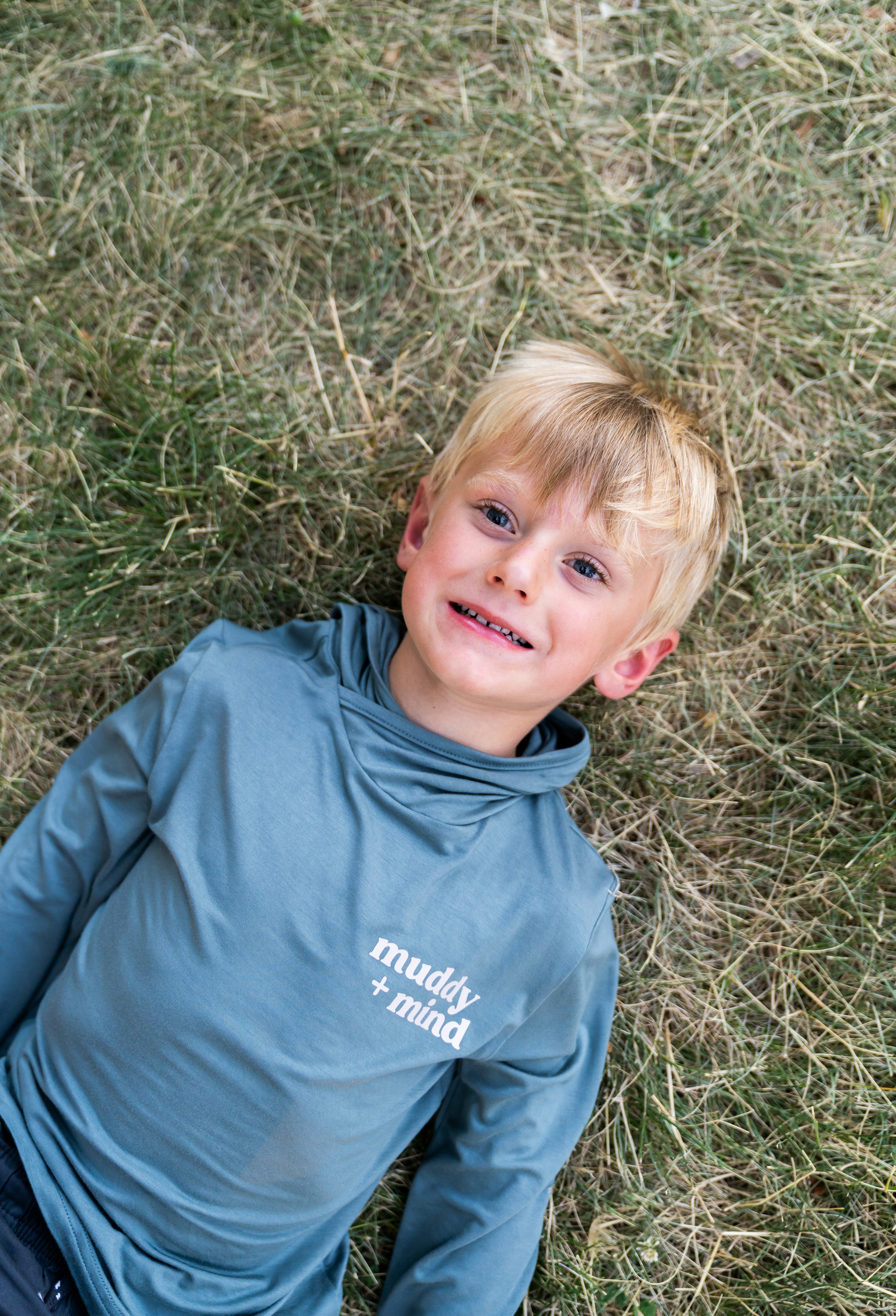 Ein kleiner Junge, der mit einer Frisbee auf dem Boden liegt