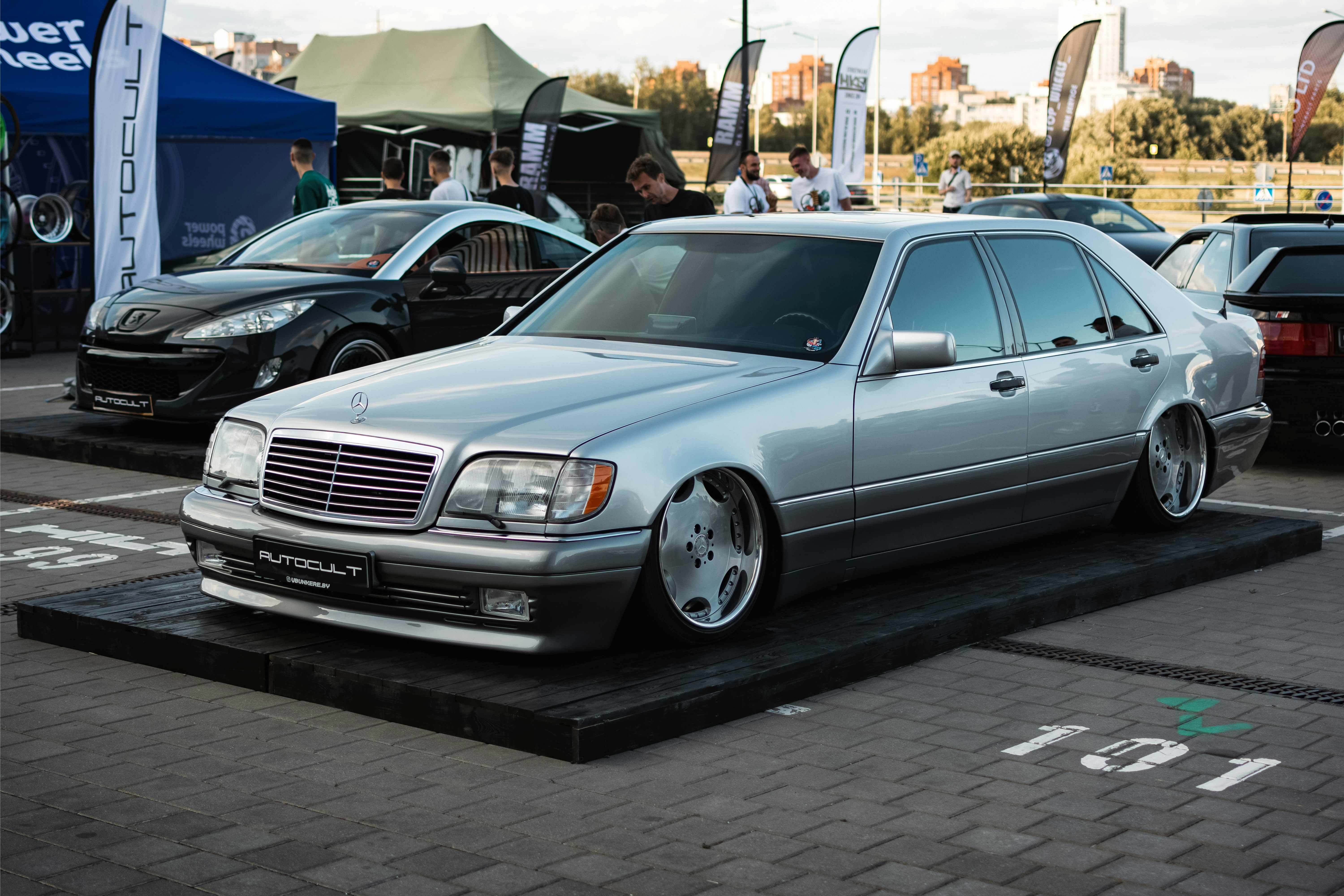 A silver car parked in a parking lot next to other cars