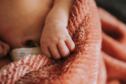 A close up of a baby wrapped in a blanket