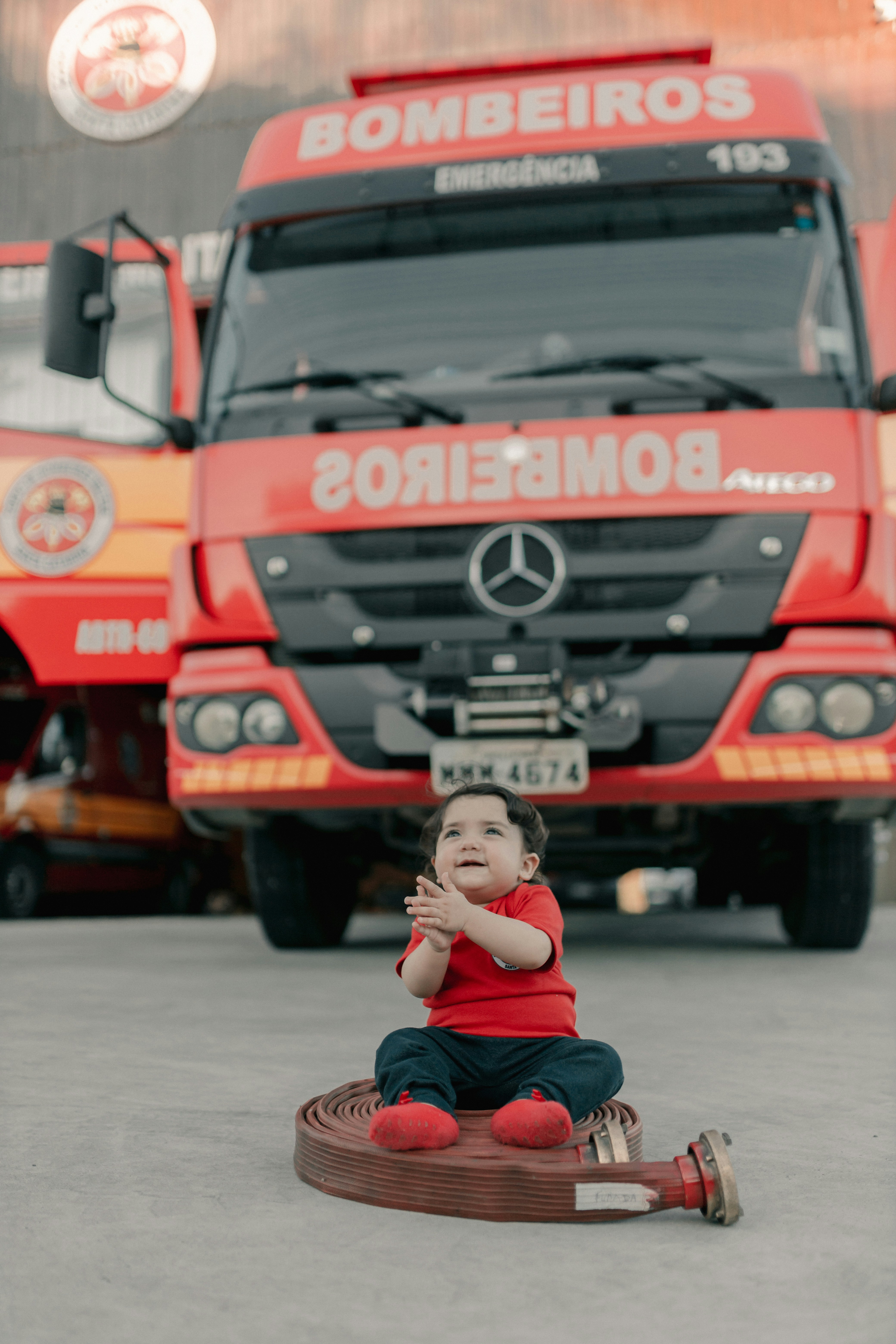 A little boy sitting on a toy in front of a truck