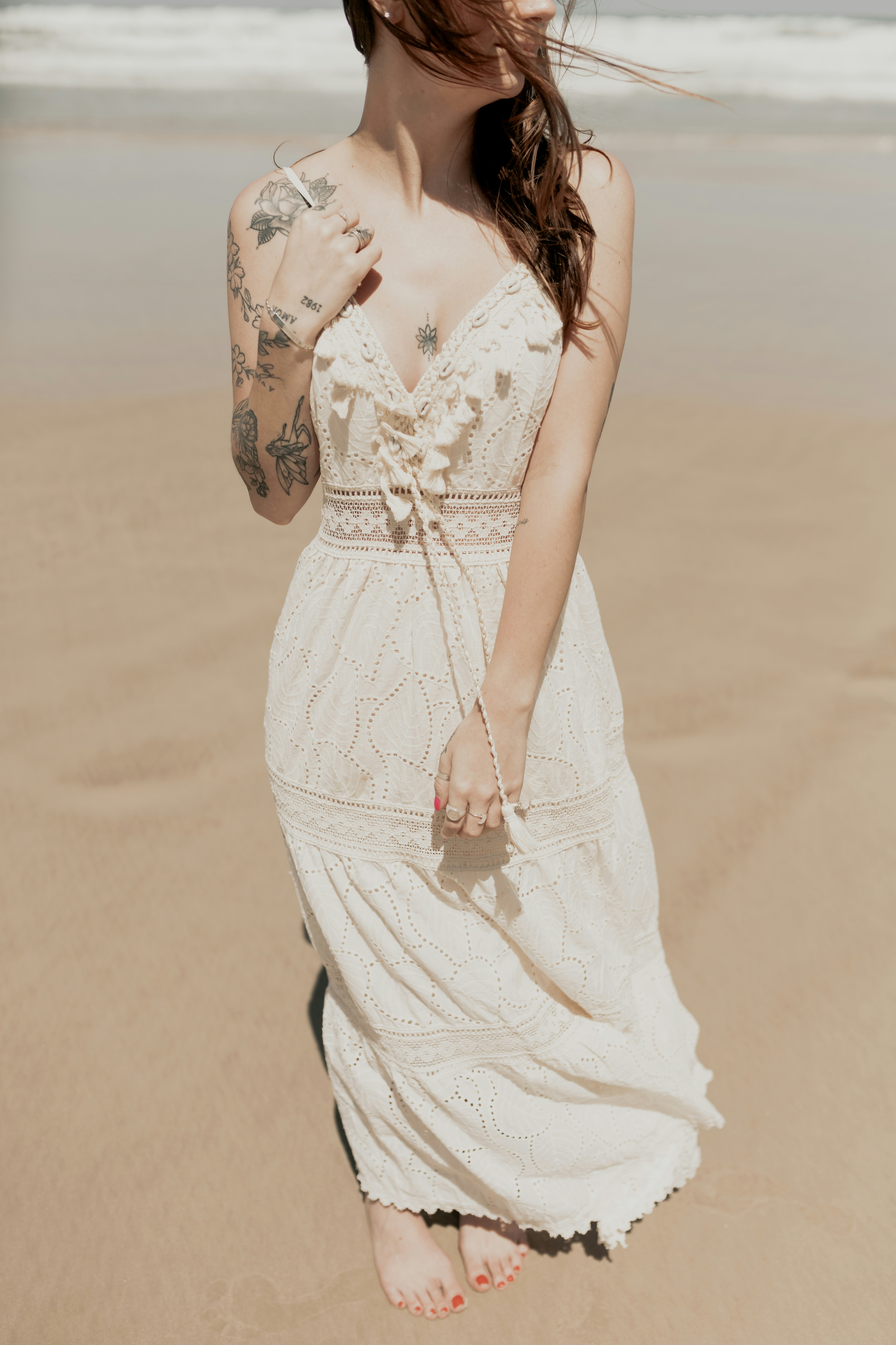 A woman in a white dress standing on a beach