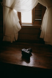 A suitcase sitting on a wooden table in front of a window
