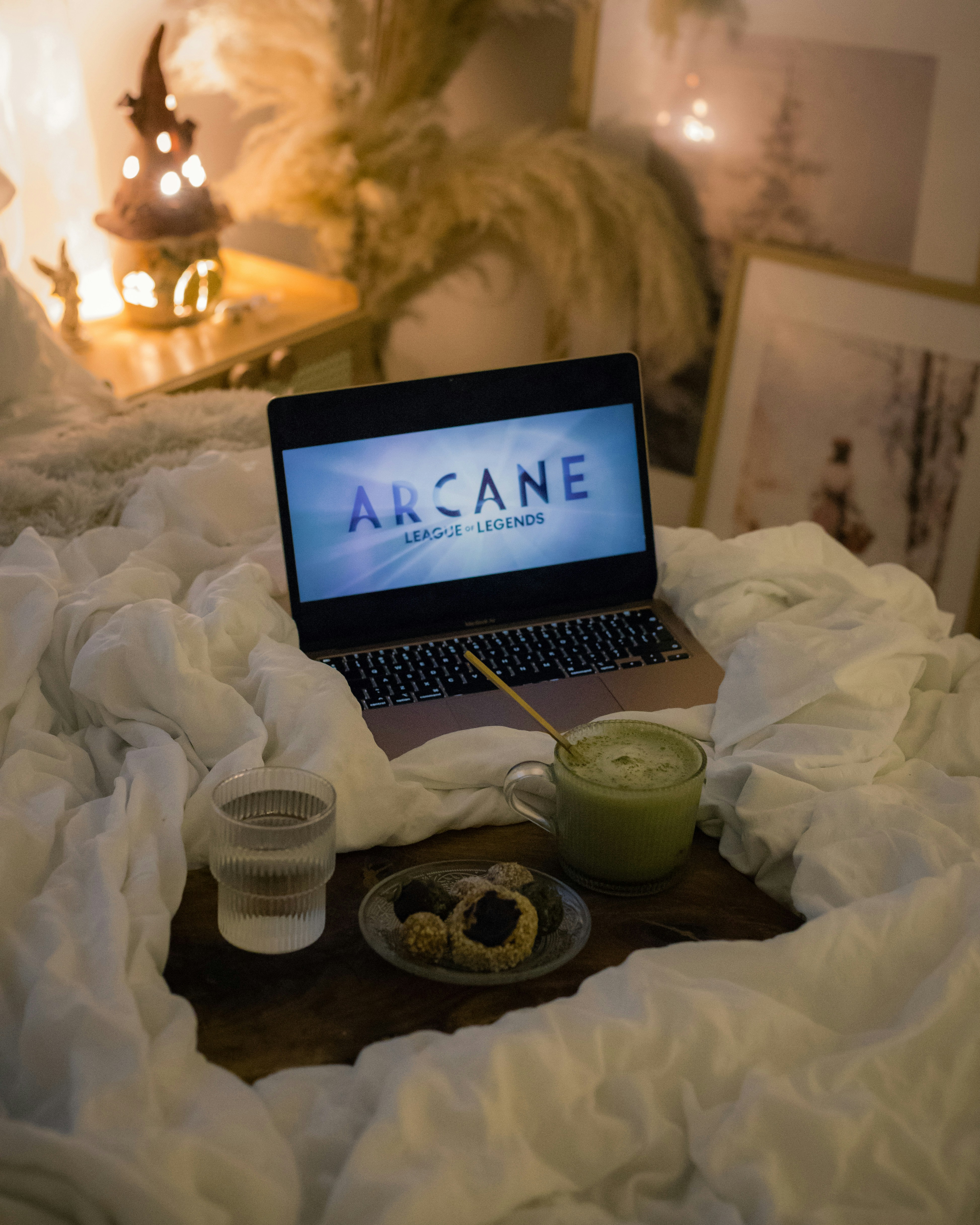 An open laptop computer sitting on top of a bed
