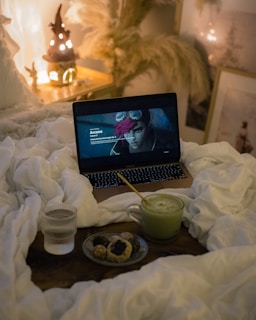 A laptop computer sitting on top of a bed