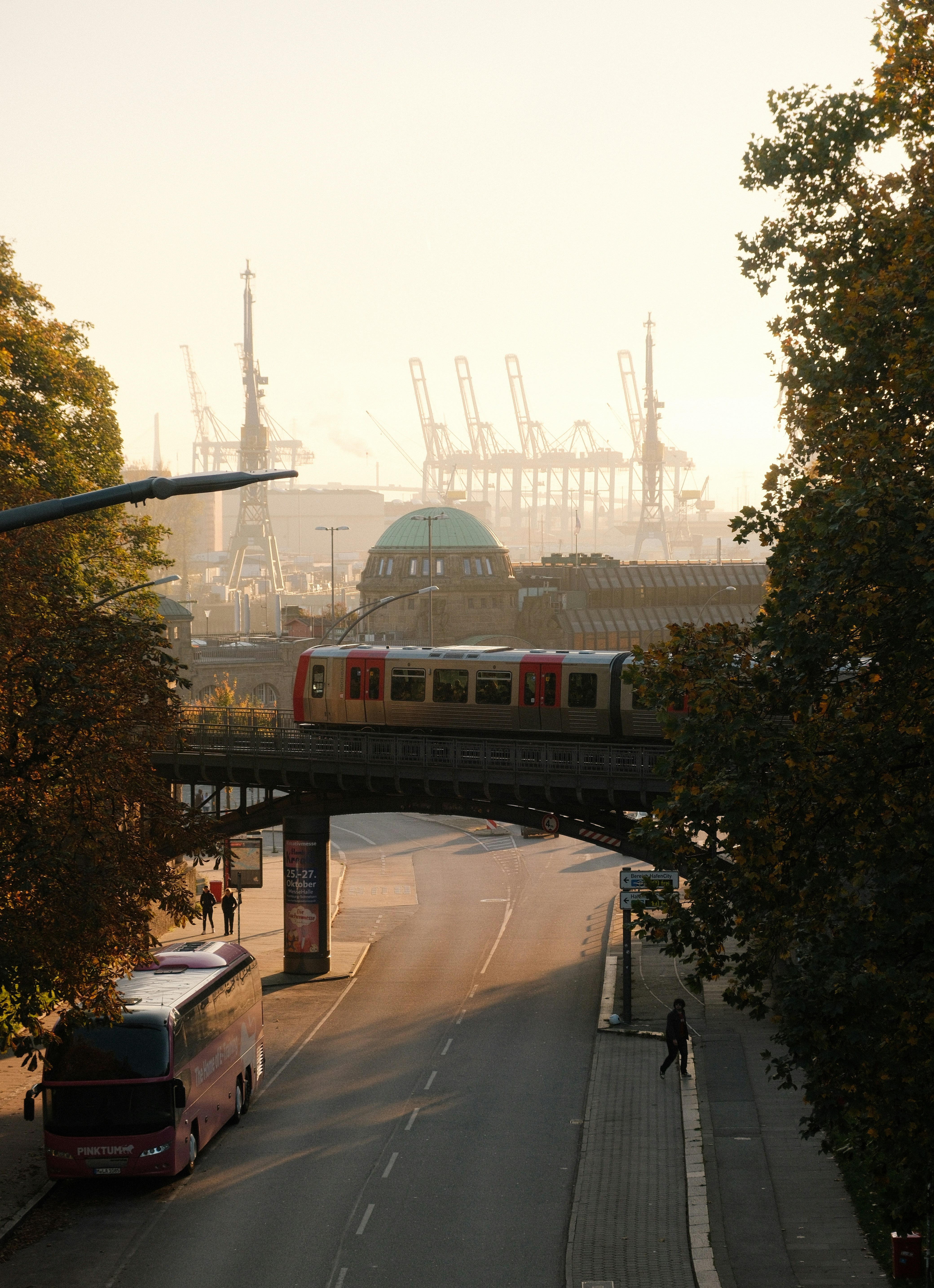 A city street with a train going over a bridge