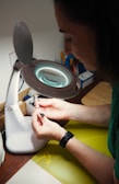 A woman sitting at a table with a magnifying glass