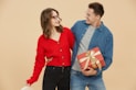 A man and a woman are holding a present