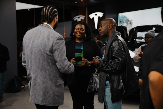 A group of people standing around talking to each other