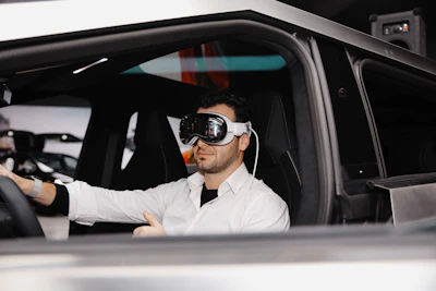 A man sitting in a car wearing a blindfold