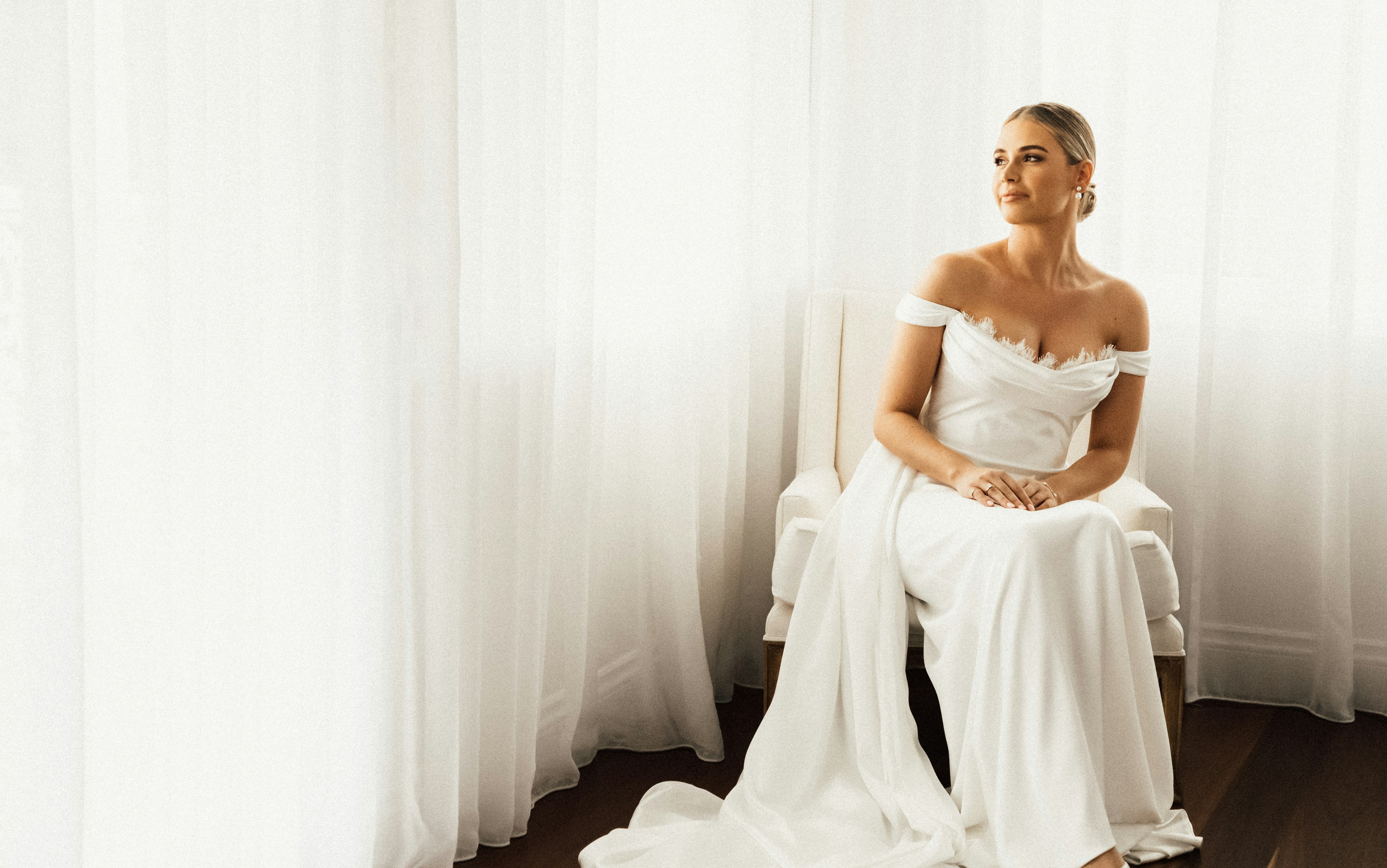 Eine Frau in einem weißen Kleid sitzt auf einem Stuhl