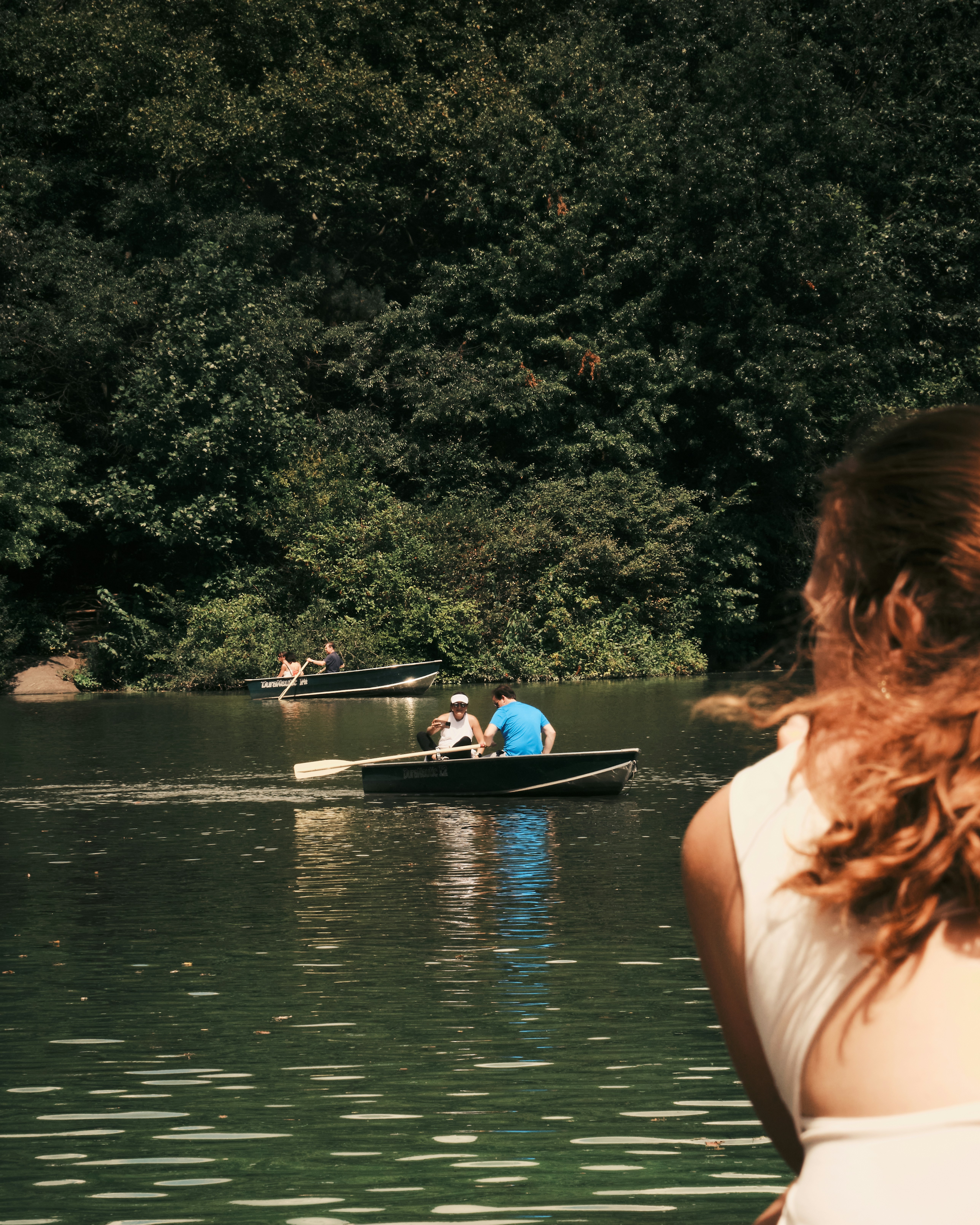 A woman looking at a man in a boat on a lake