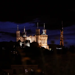 A castle lit up at night with a dark sky