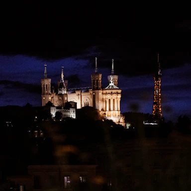 A castle lit up at night with a dark sky