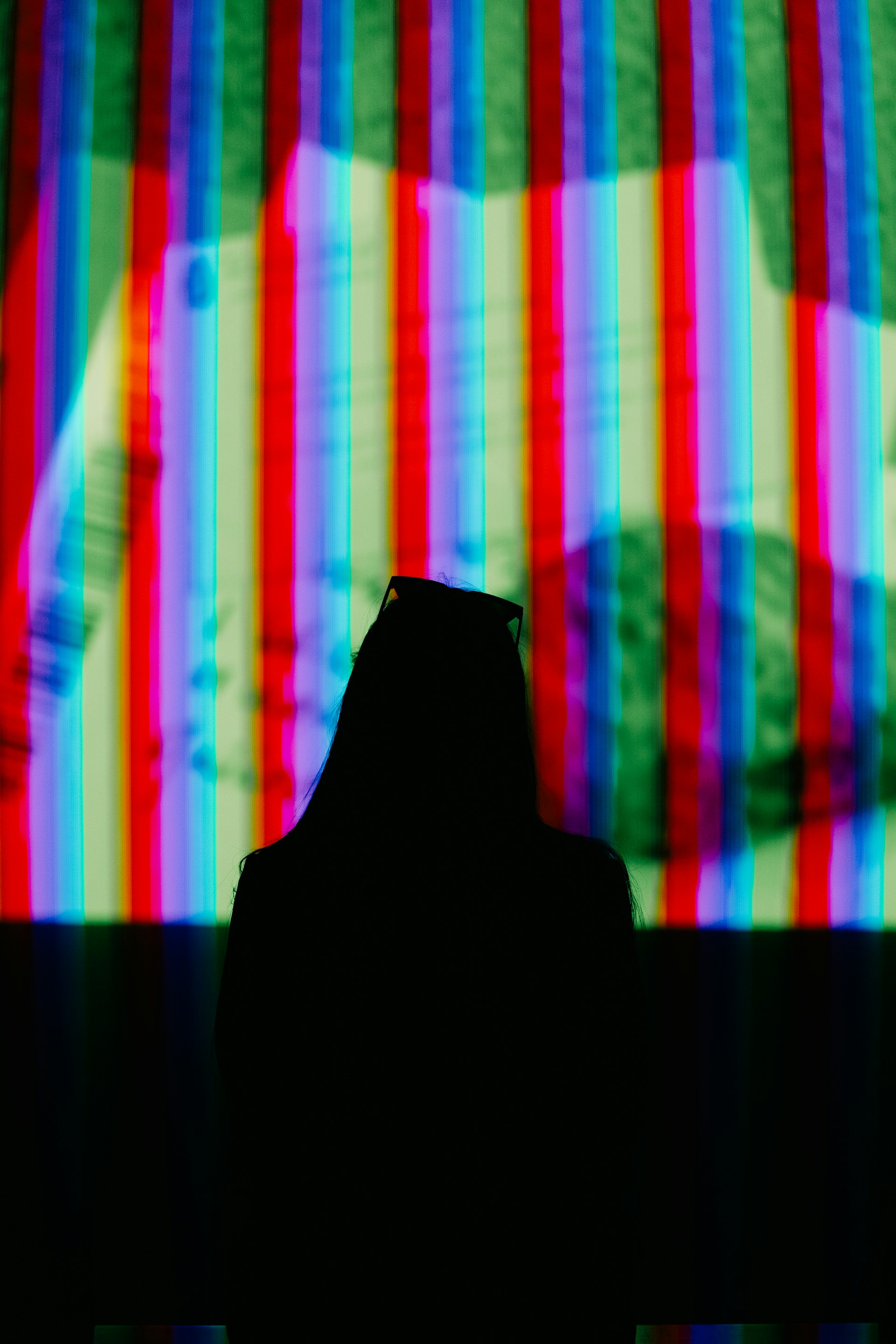 A silhouette of a person in front of a television