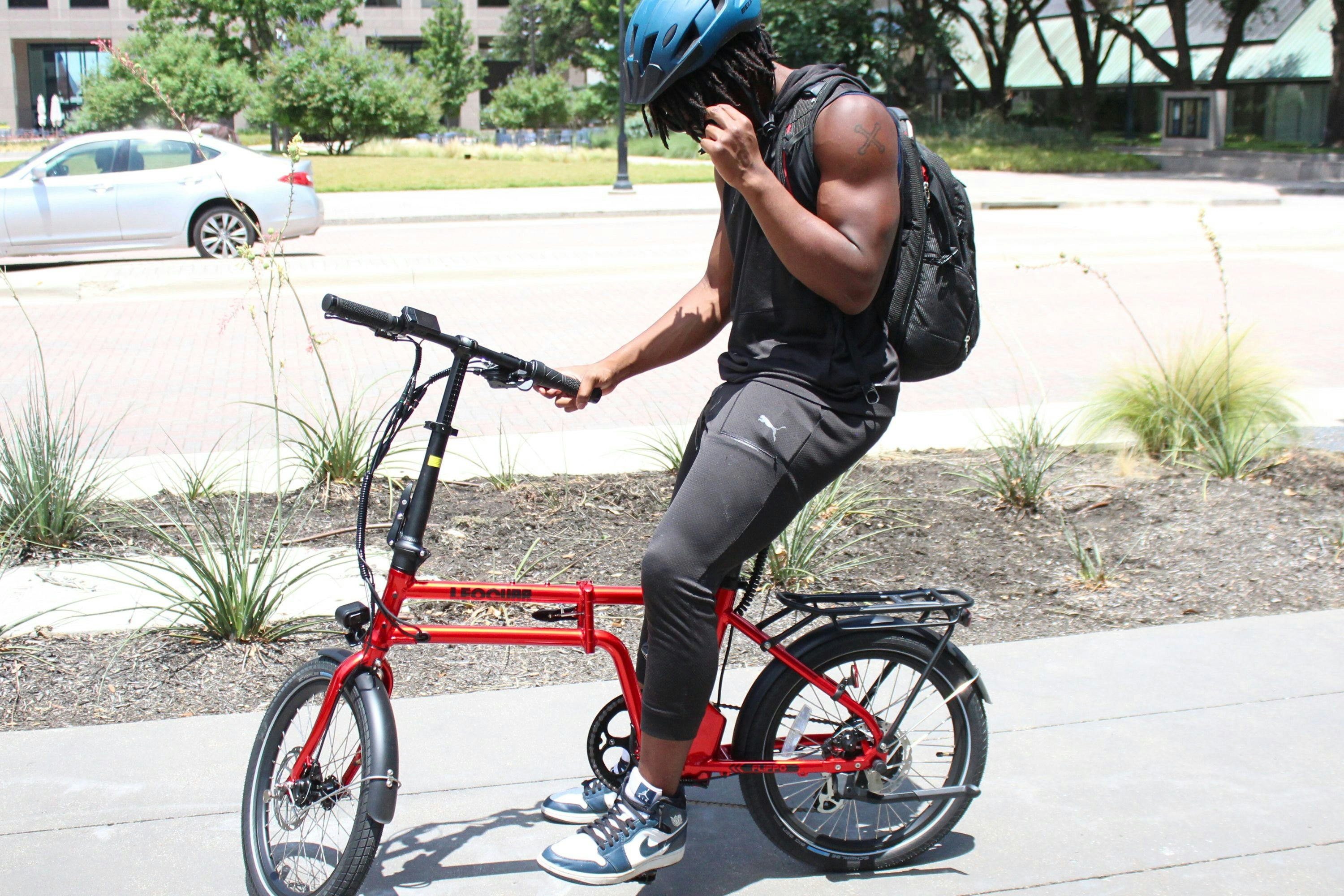 A man riding a bike while talking on a cell phone