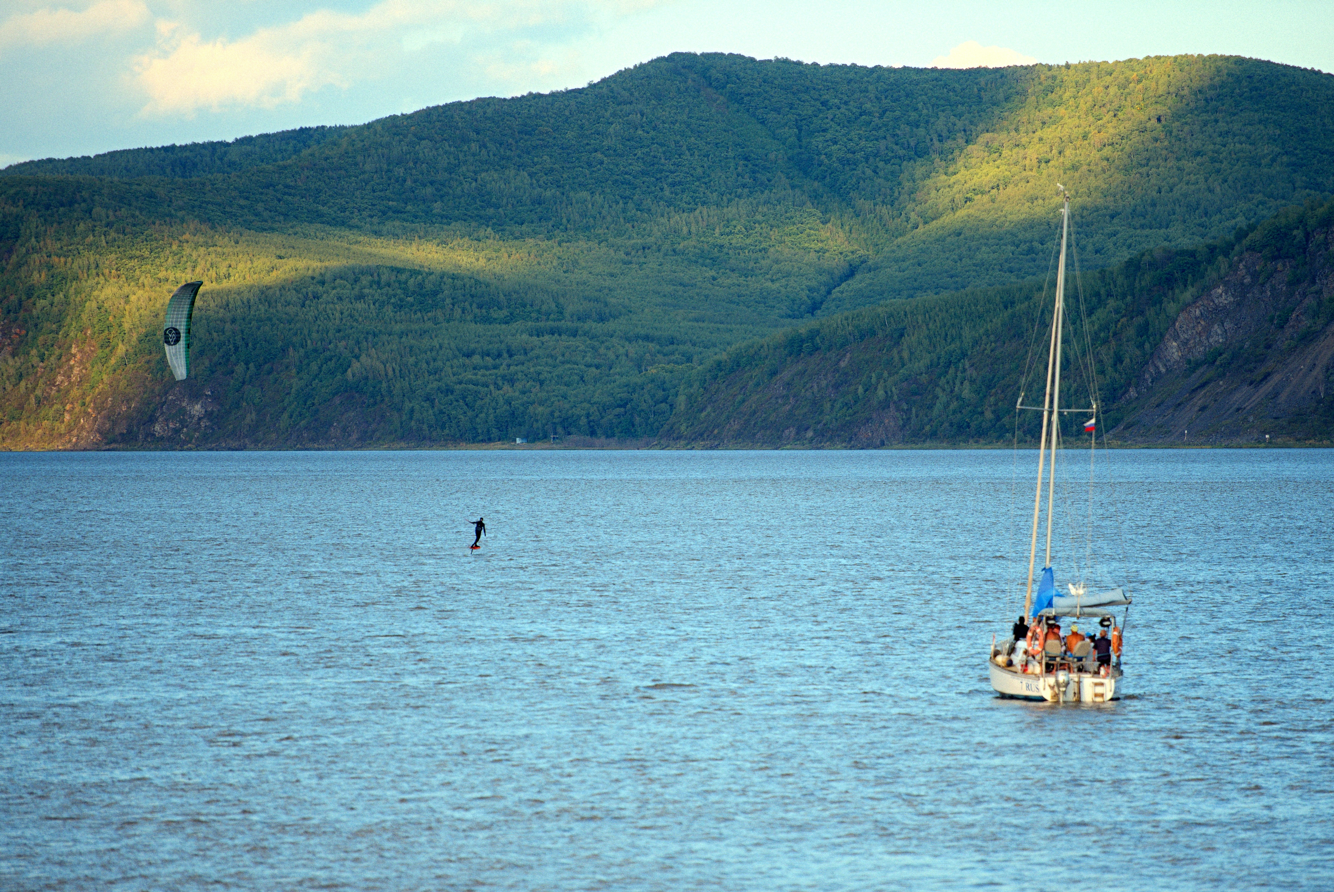 Amur River, Russia - Hydrofoil and yacht on the river with a hill in the background
