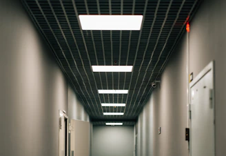 A long hallway with two refrigerators in it