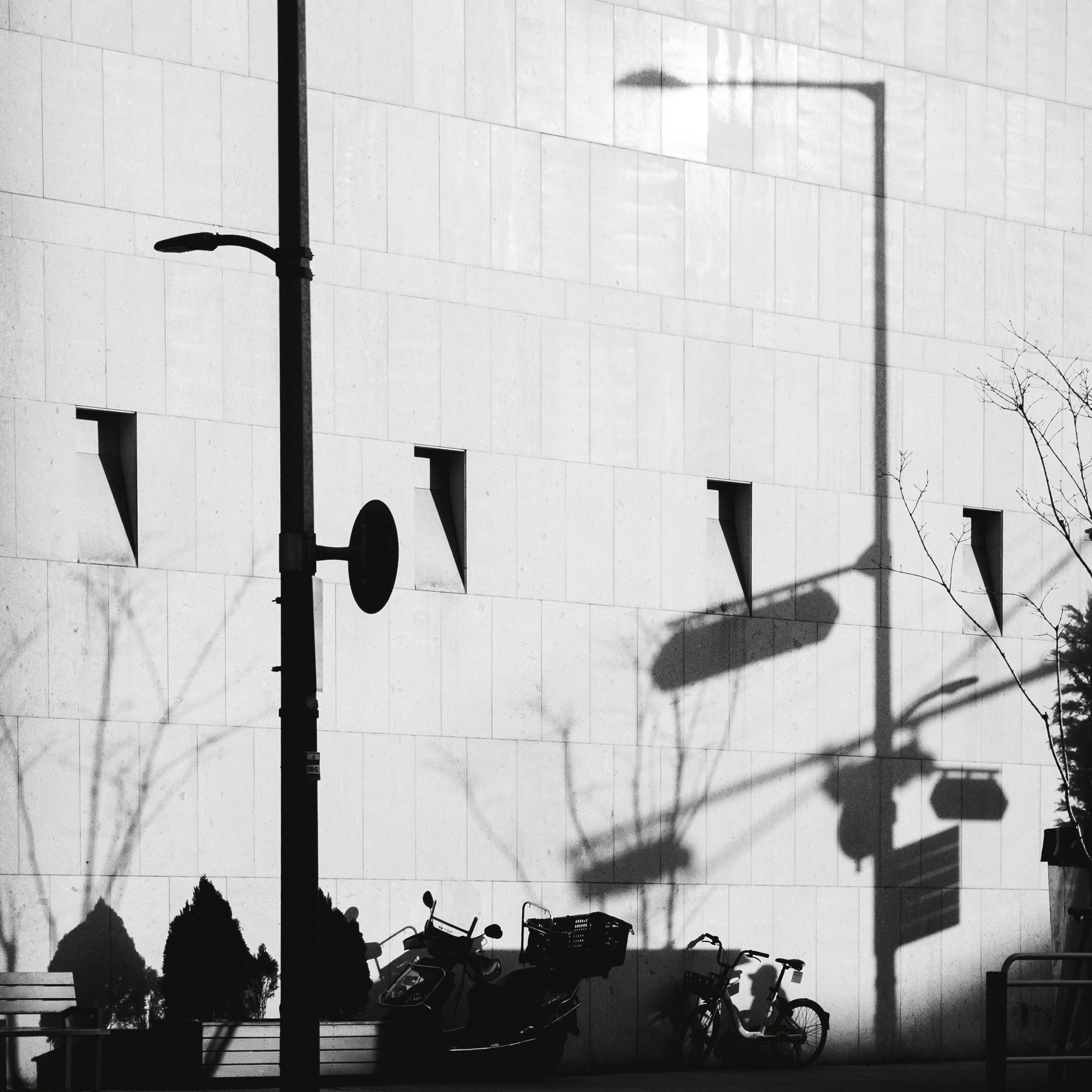 A black and white photo of a motorcycle parked in front of a building