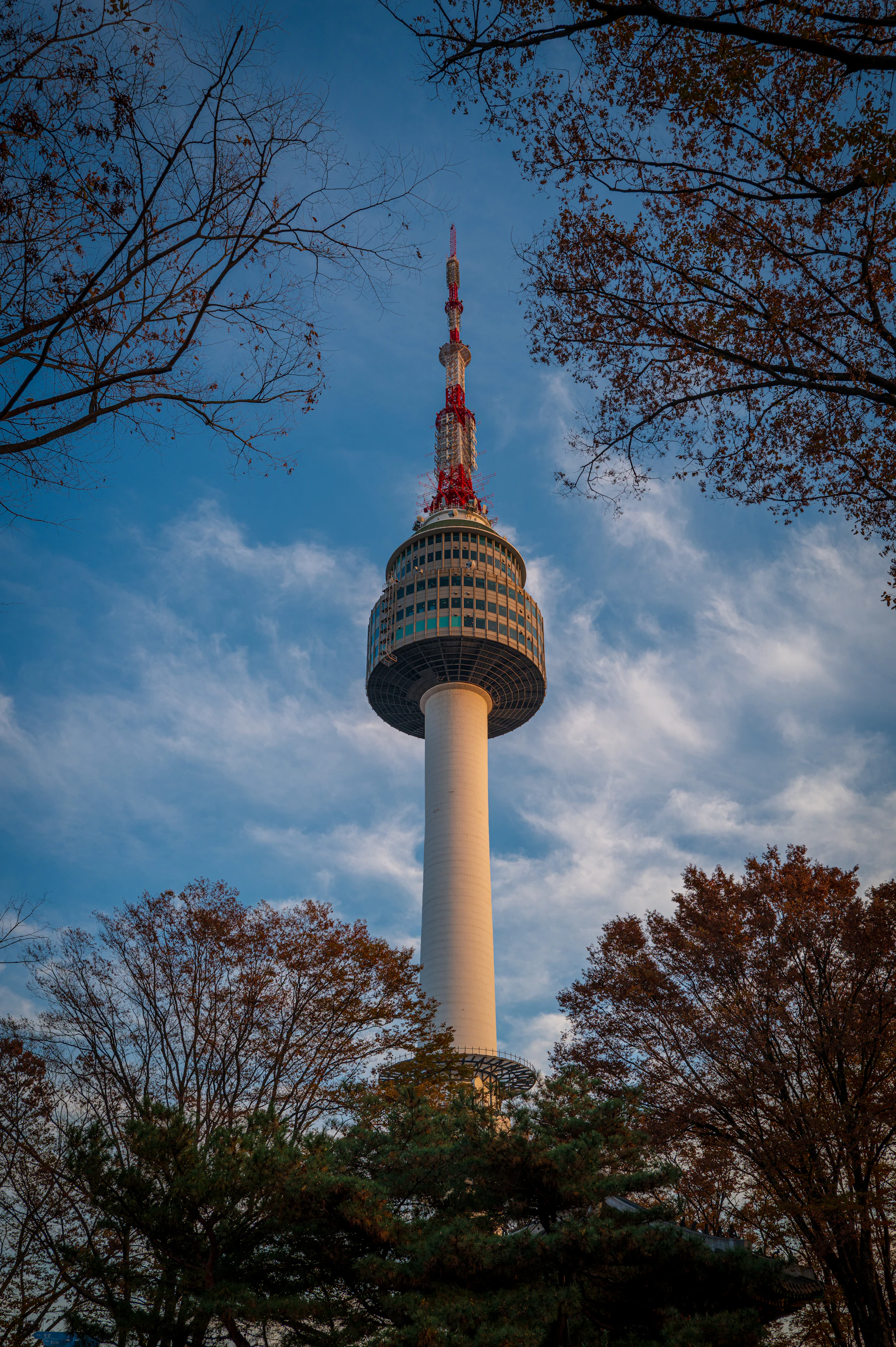 N Seoul Tower’s observation deck and red-and-white antenna above Namsan’s trees