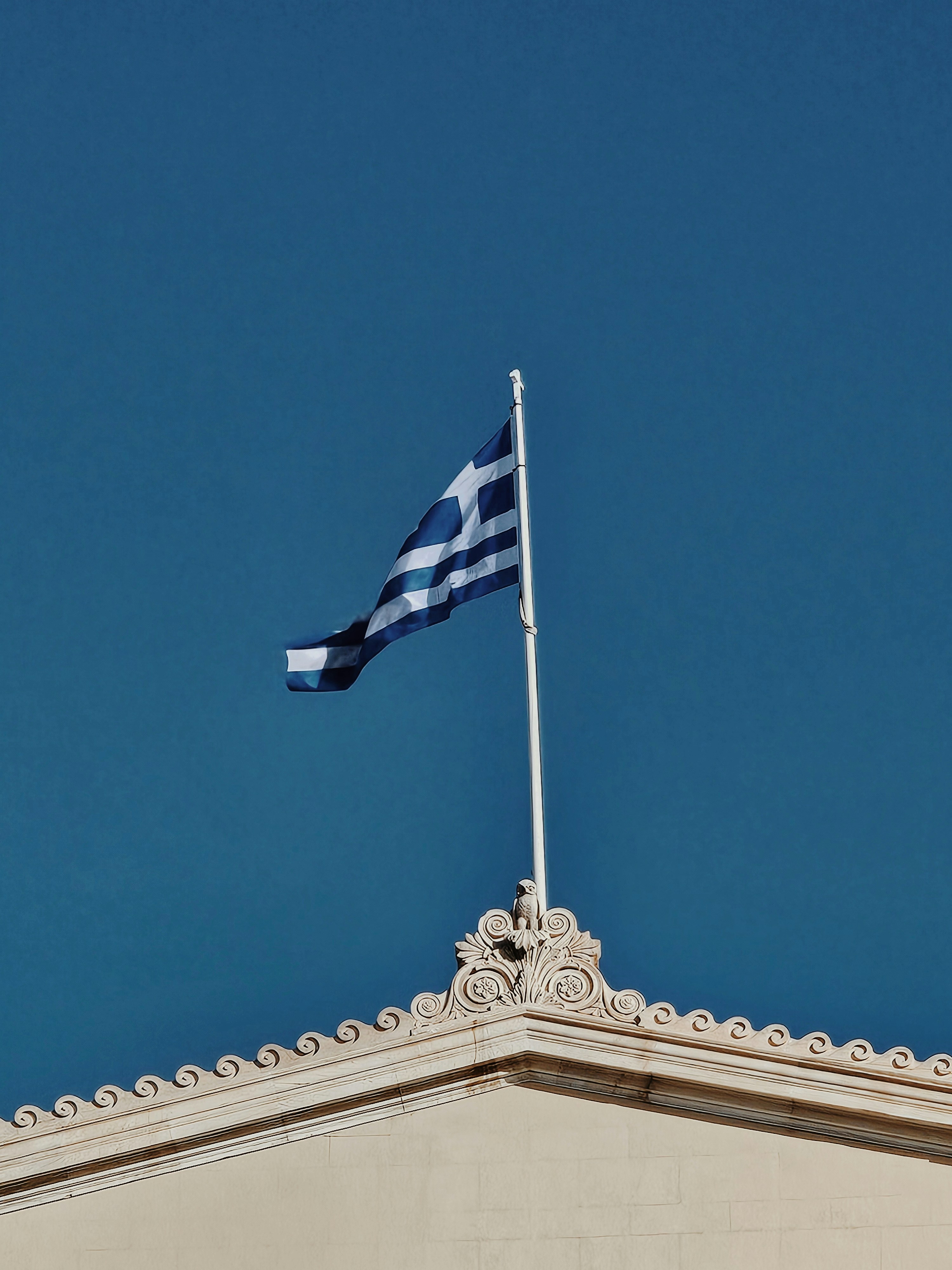 A greek flag flying on top of a building