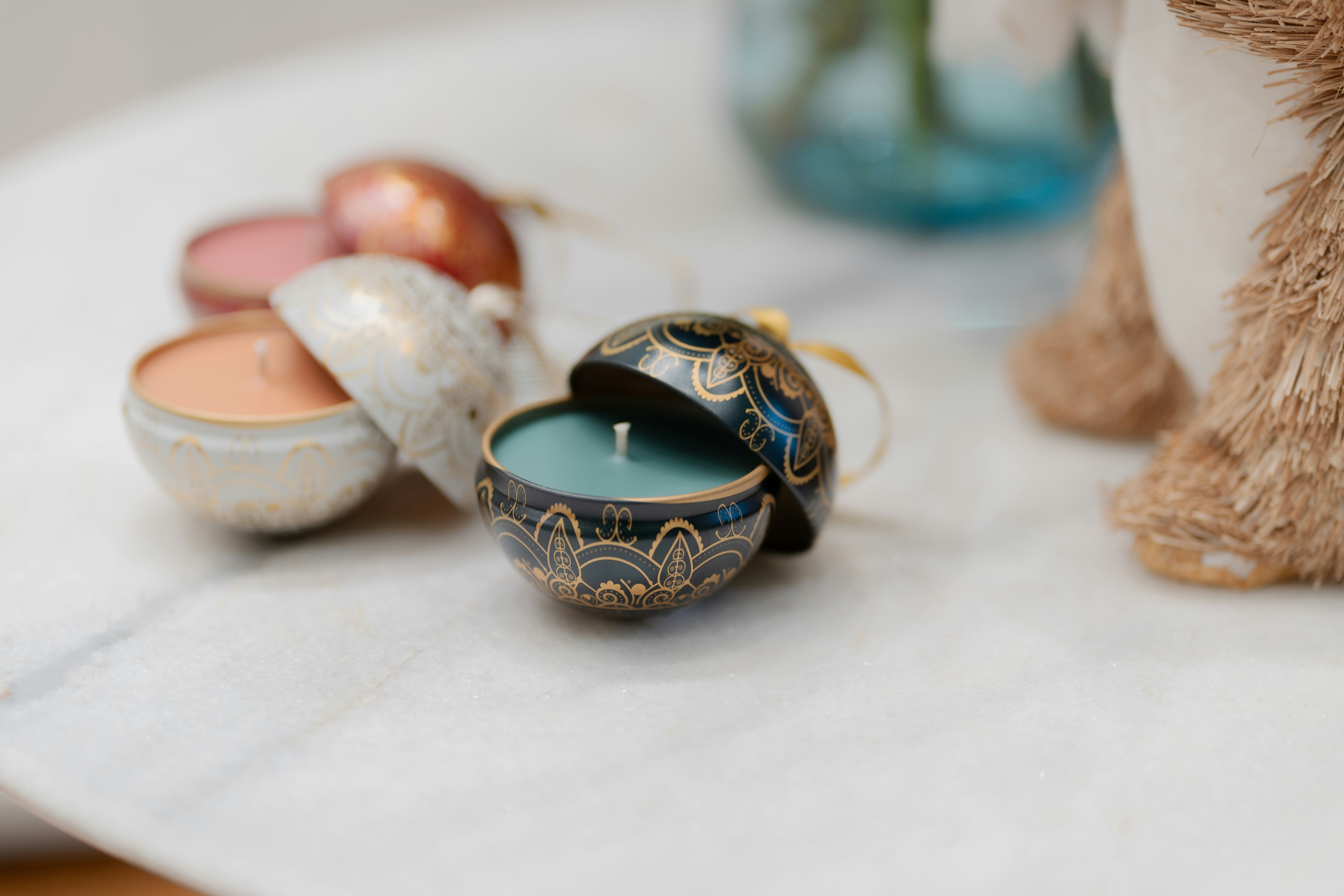 Luxury scented candles with gold labels and rose petals on dark marble surface