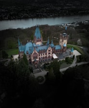 An aerial view of a castle with a lake in the background