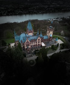 An aerial view of a castle with a lake in the background
