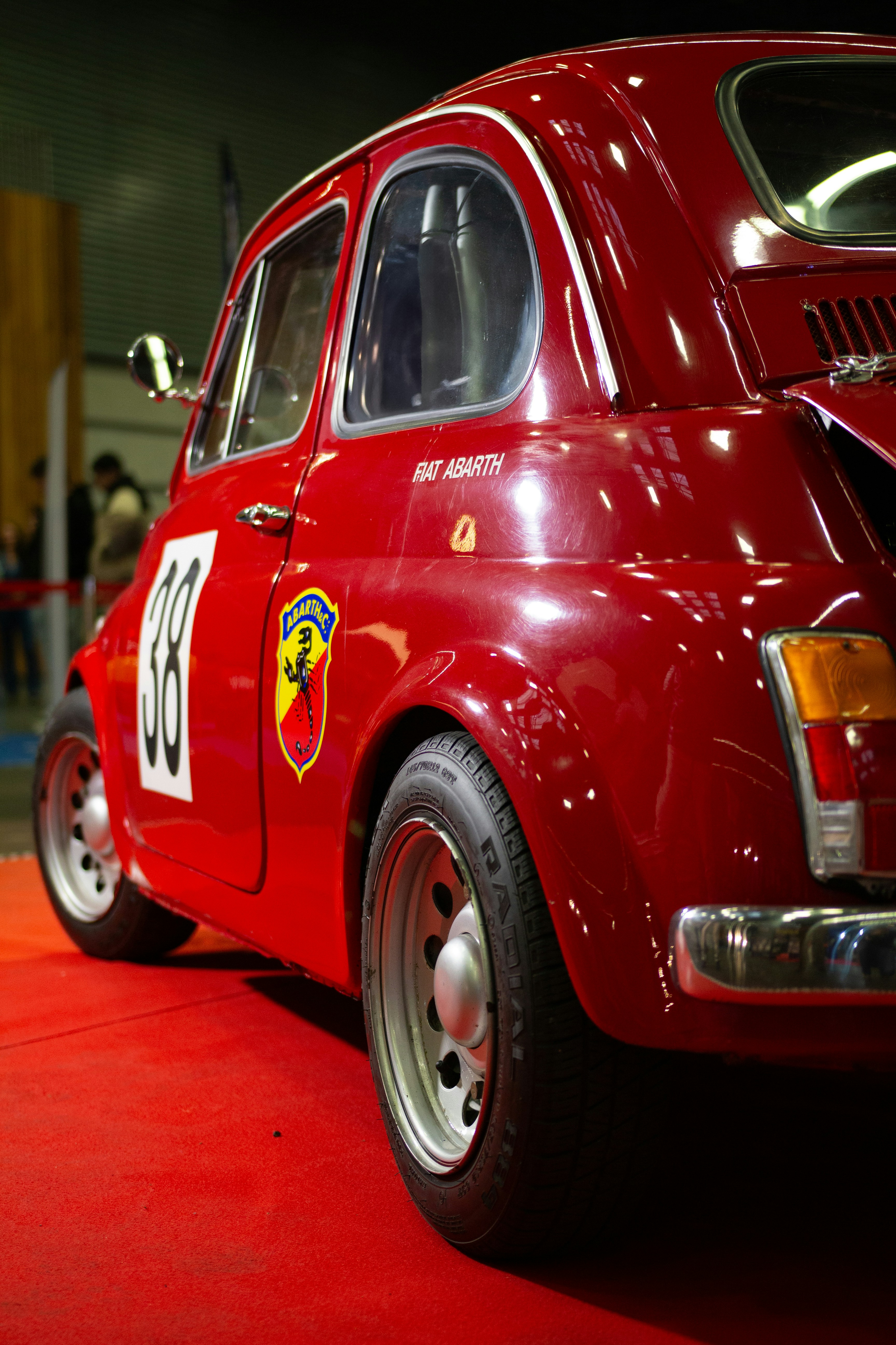 A red car is parked on a red carpet