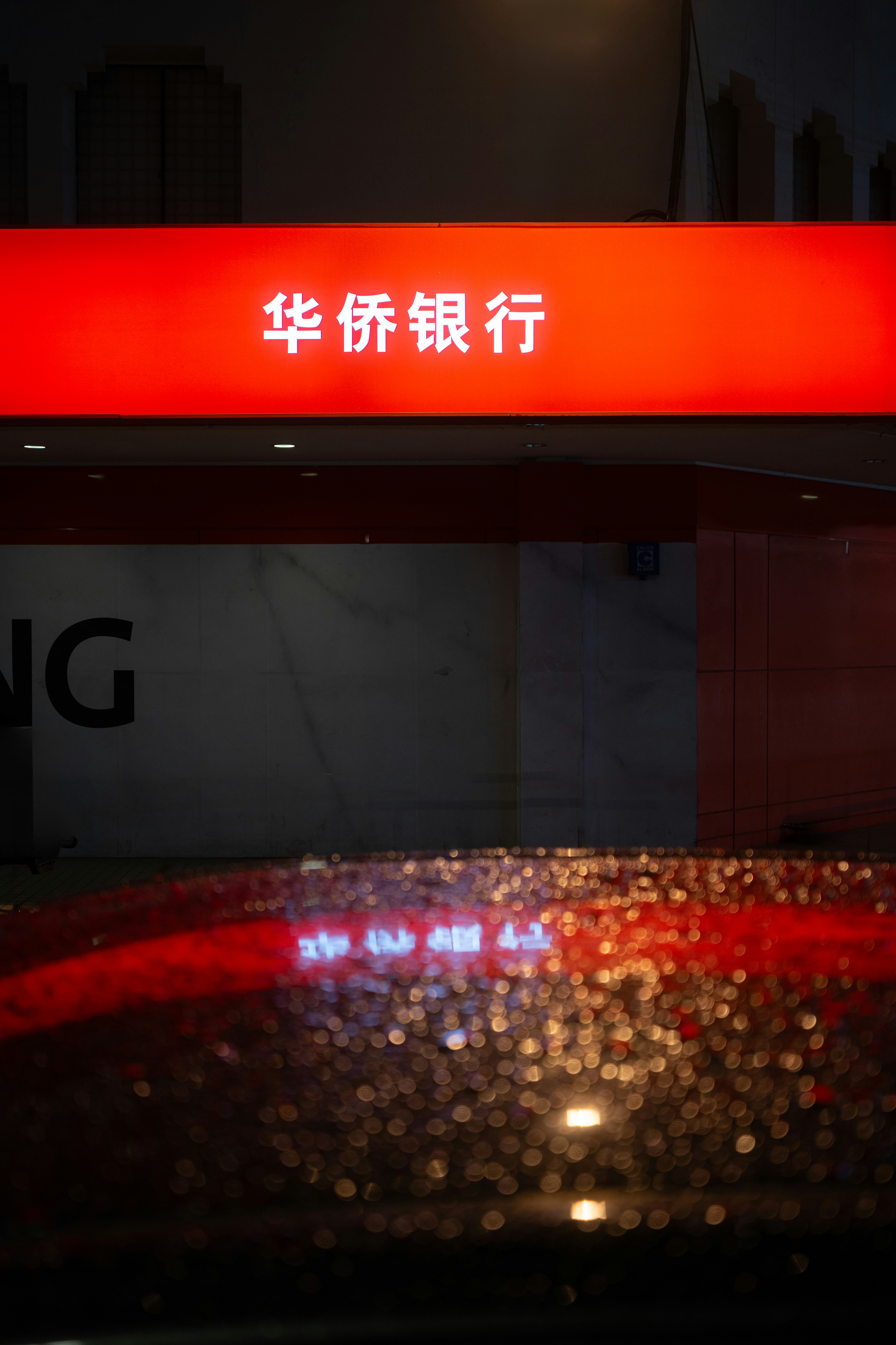 A red sign that is on the side of a building