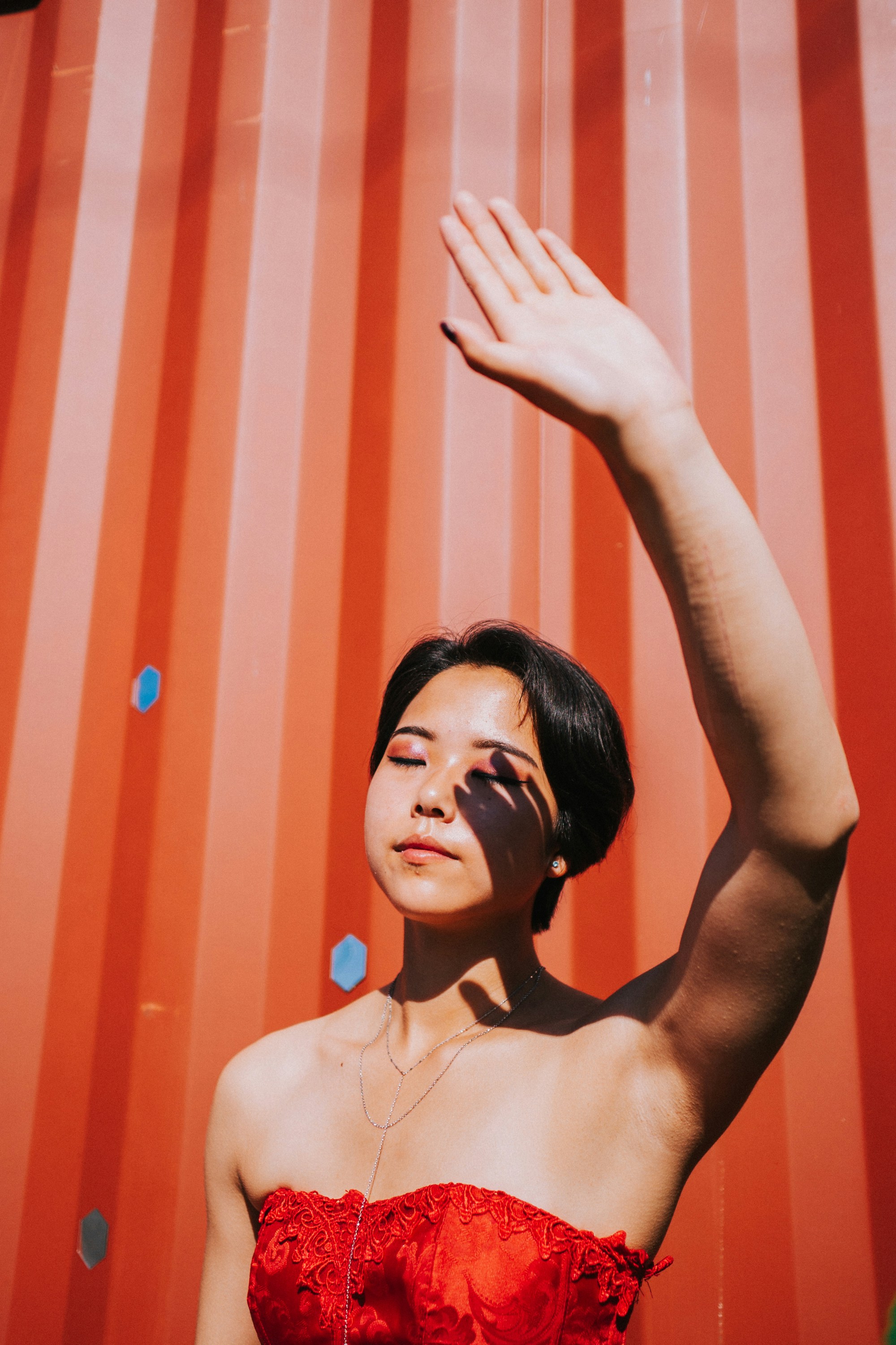 A woman in a red dress standing in front of a red wall