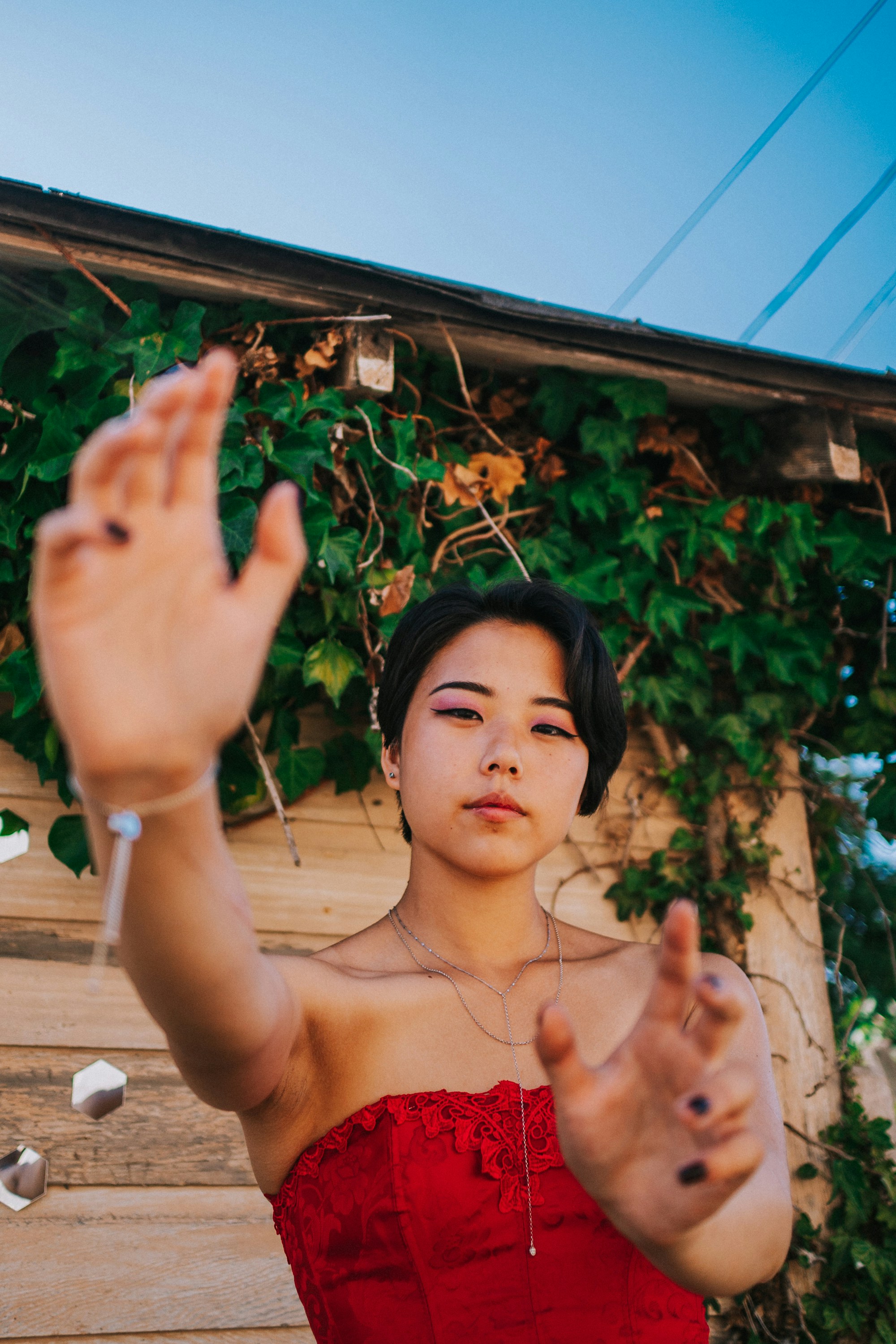 A woman in a red dress standing in front of a house