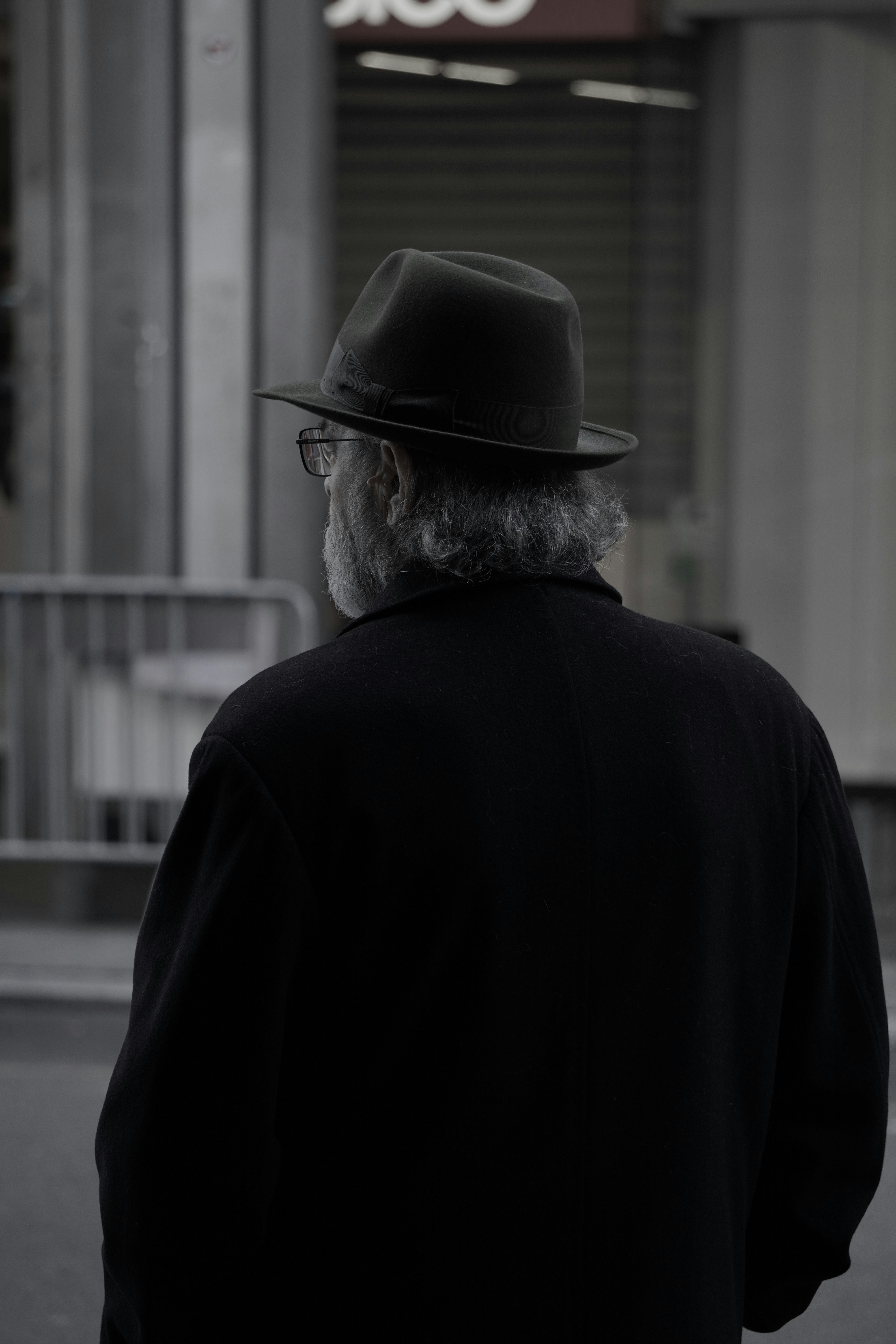 Um homem com um chapéu está andando pela rua