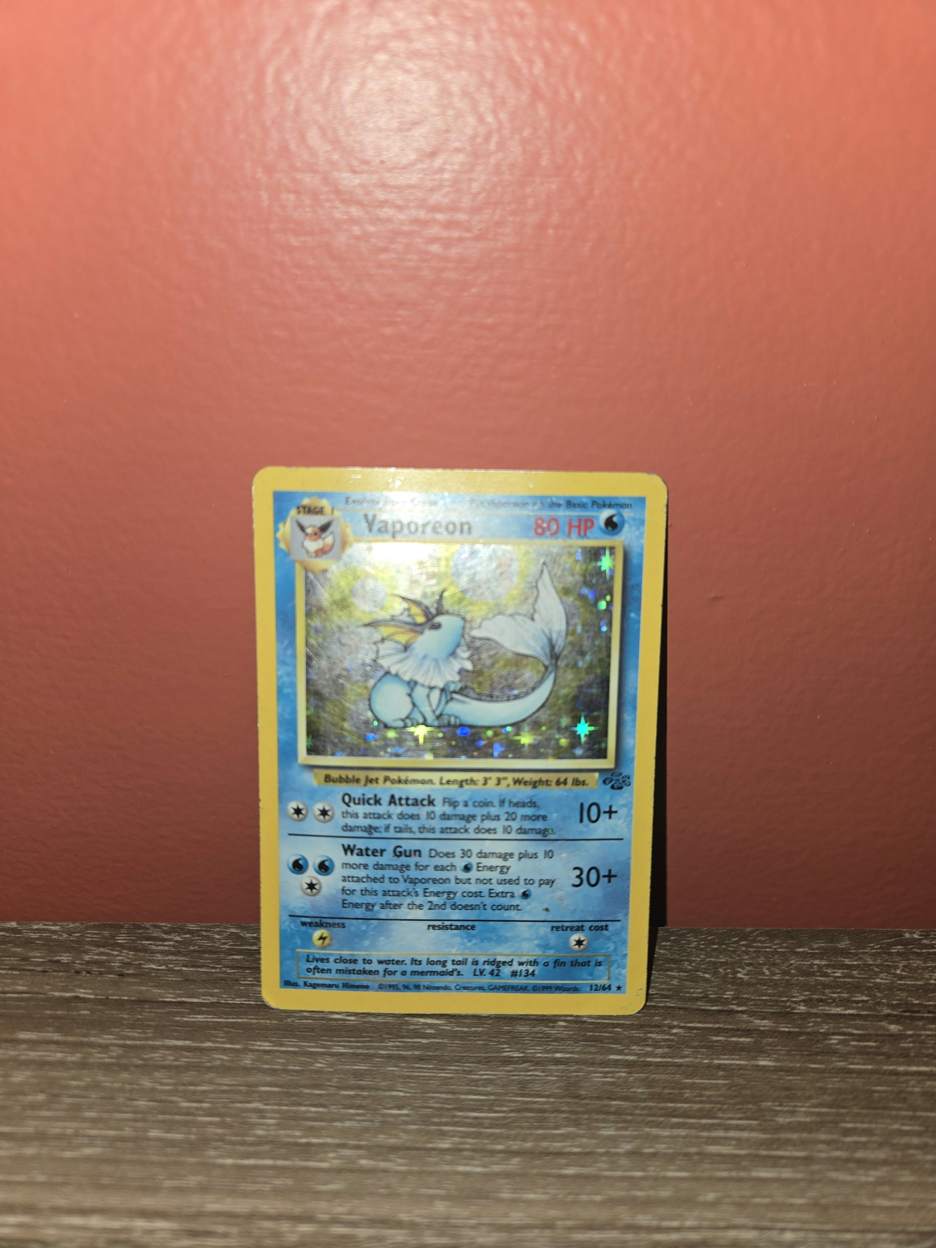 Holographic Pokémon card close-up with blue neon light on dark background