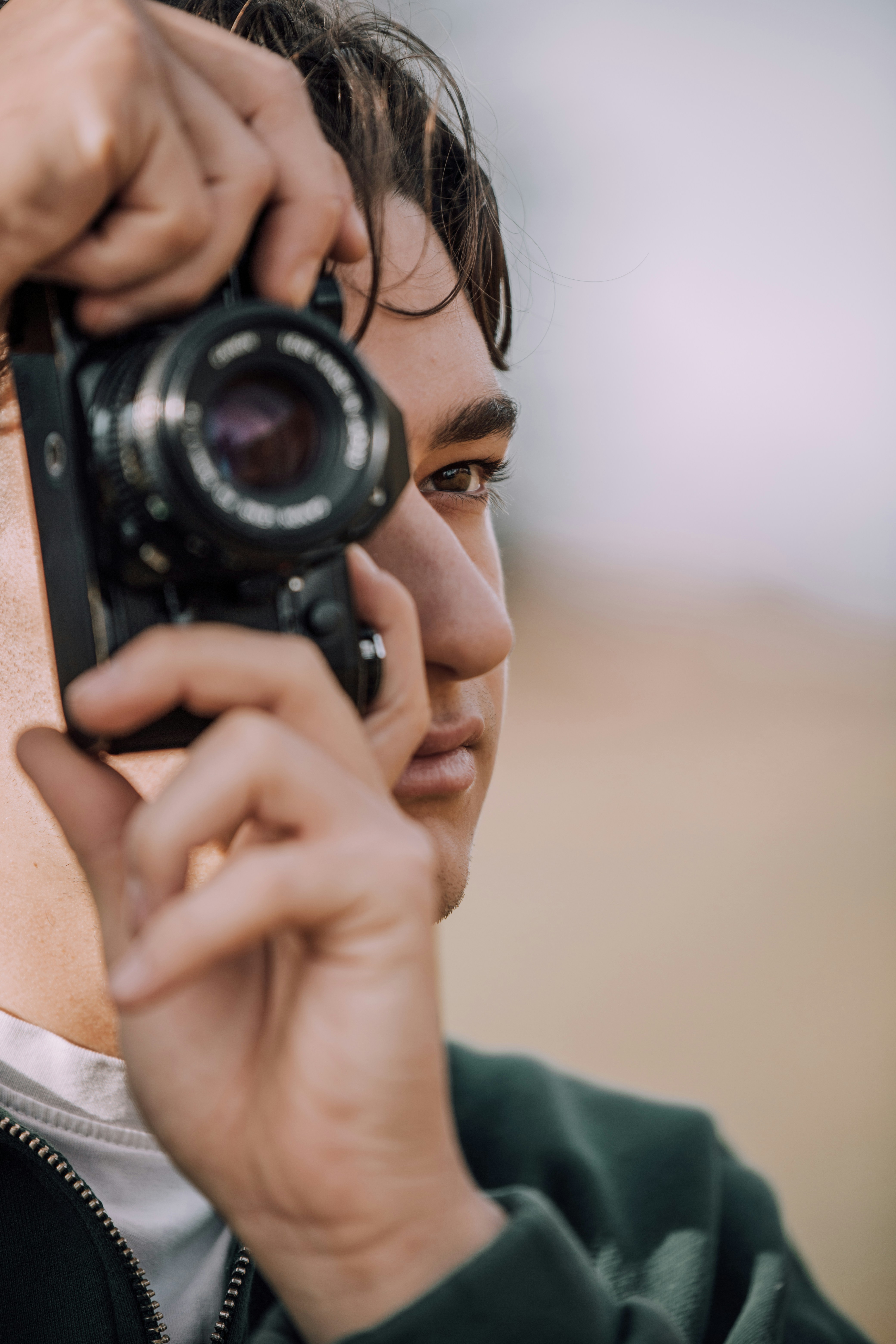 A man holding a camera up to his face