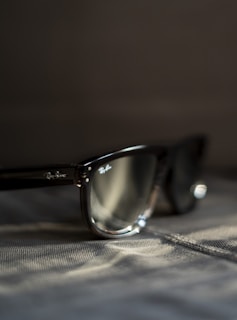 A pair of sunglasses sitting on top of a bed