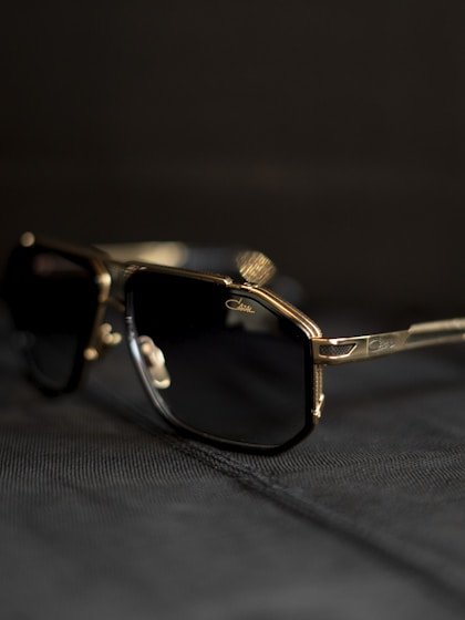 A pair of sunglasses sitting on top of a bed