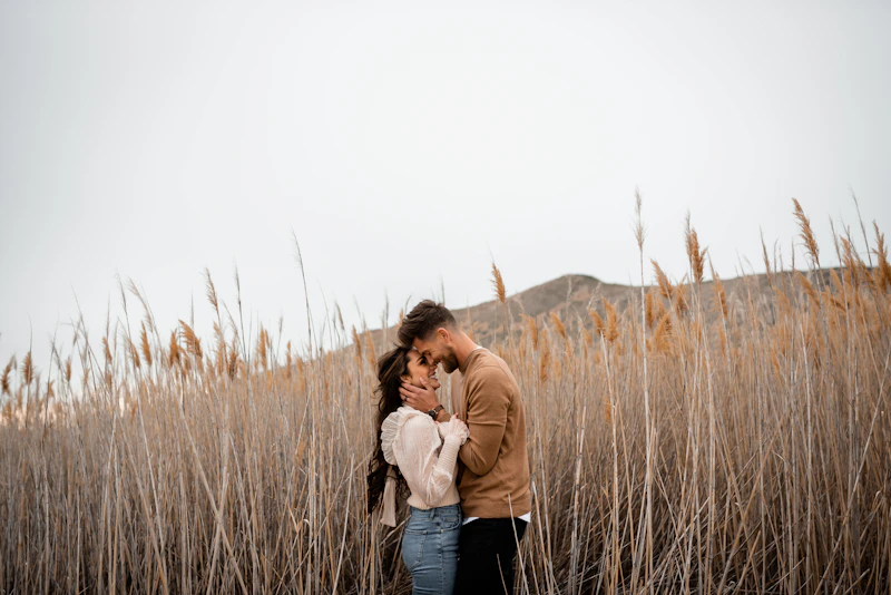 man and woman standing together in tall grass