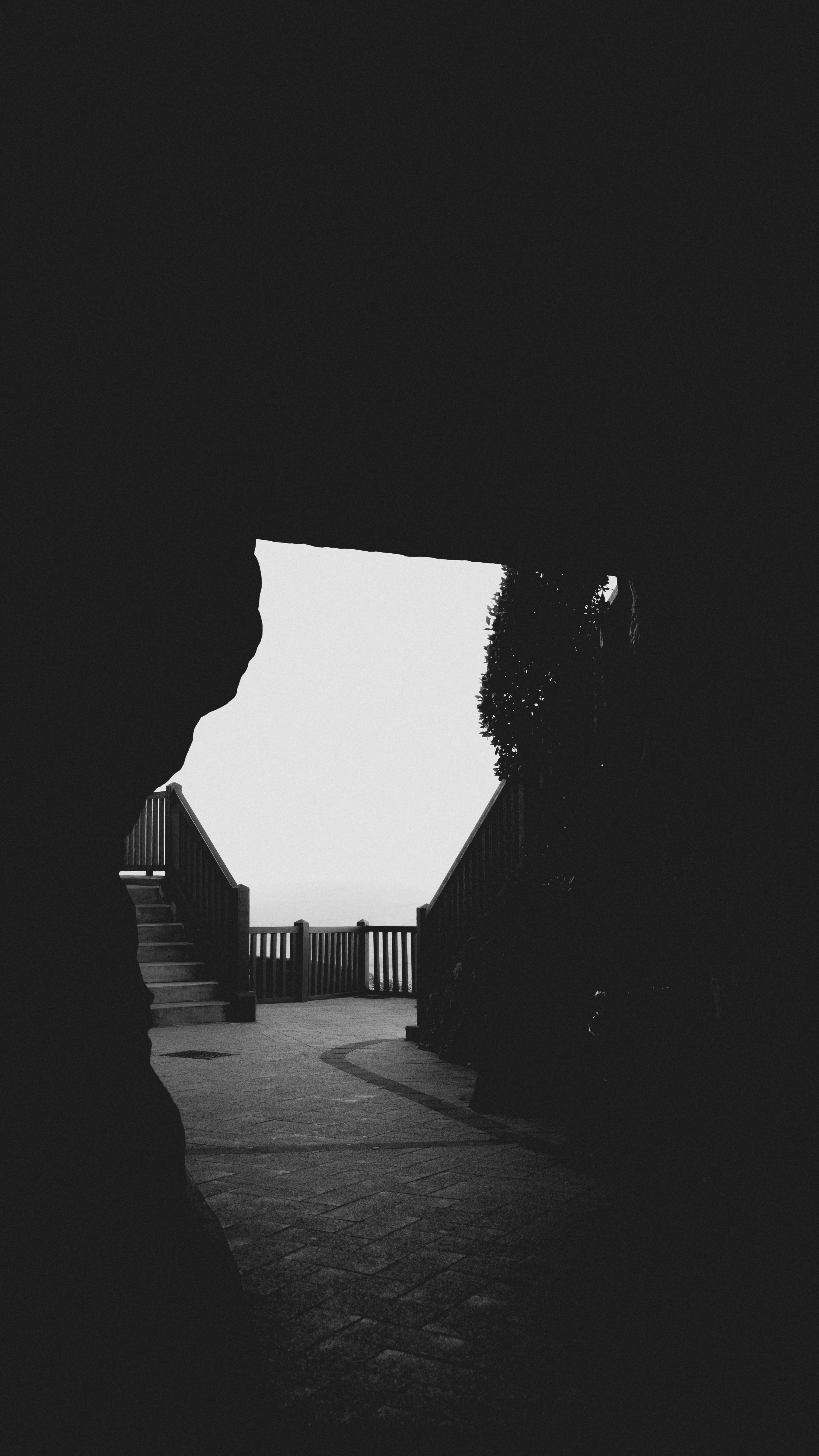 A black and white photo of a person looking out a window