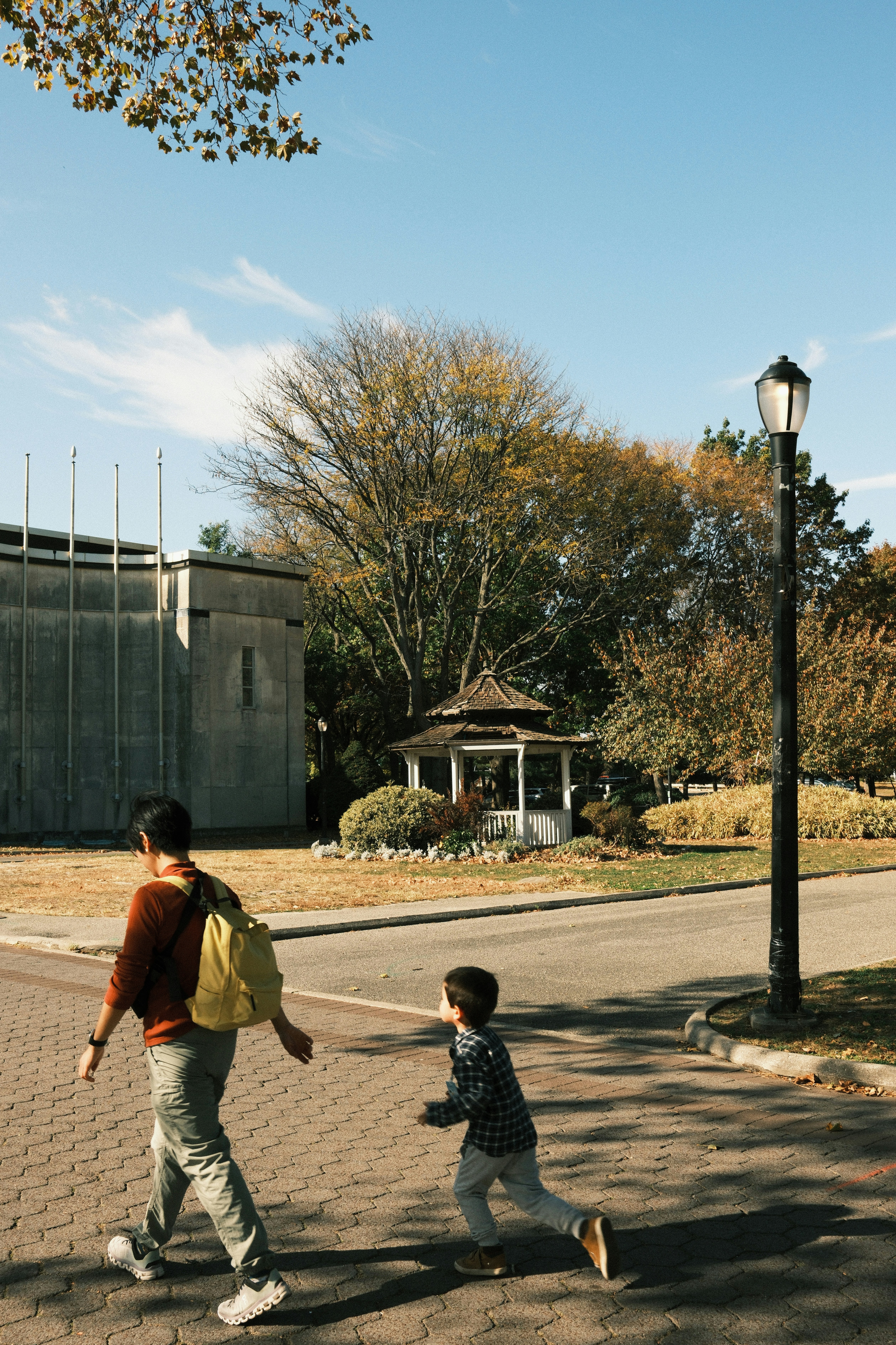 A man and a child walking down a street