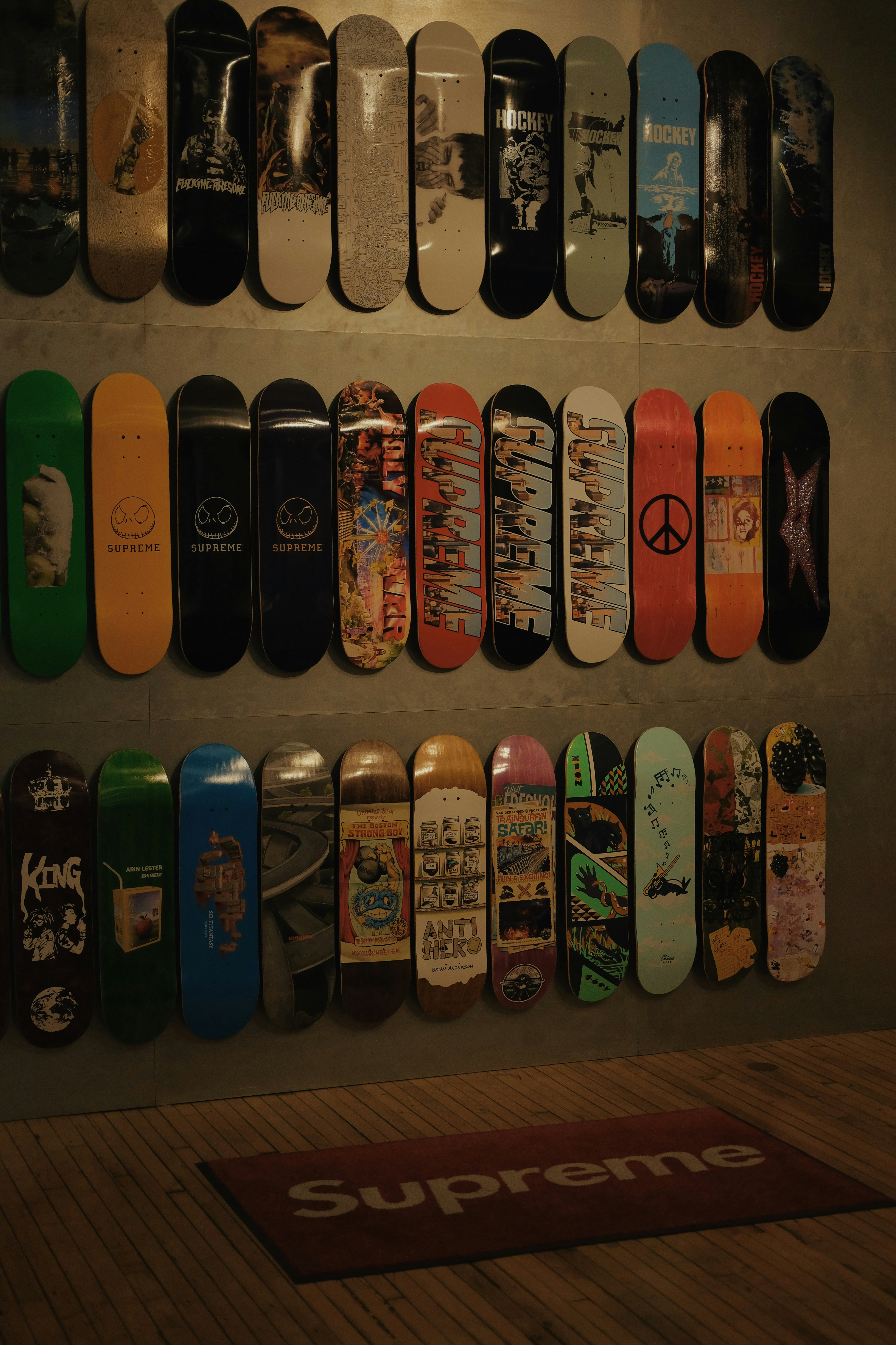 A bunch of skateboards are hanging on a wall