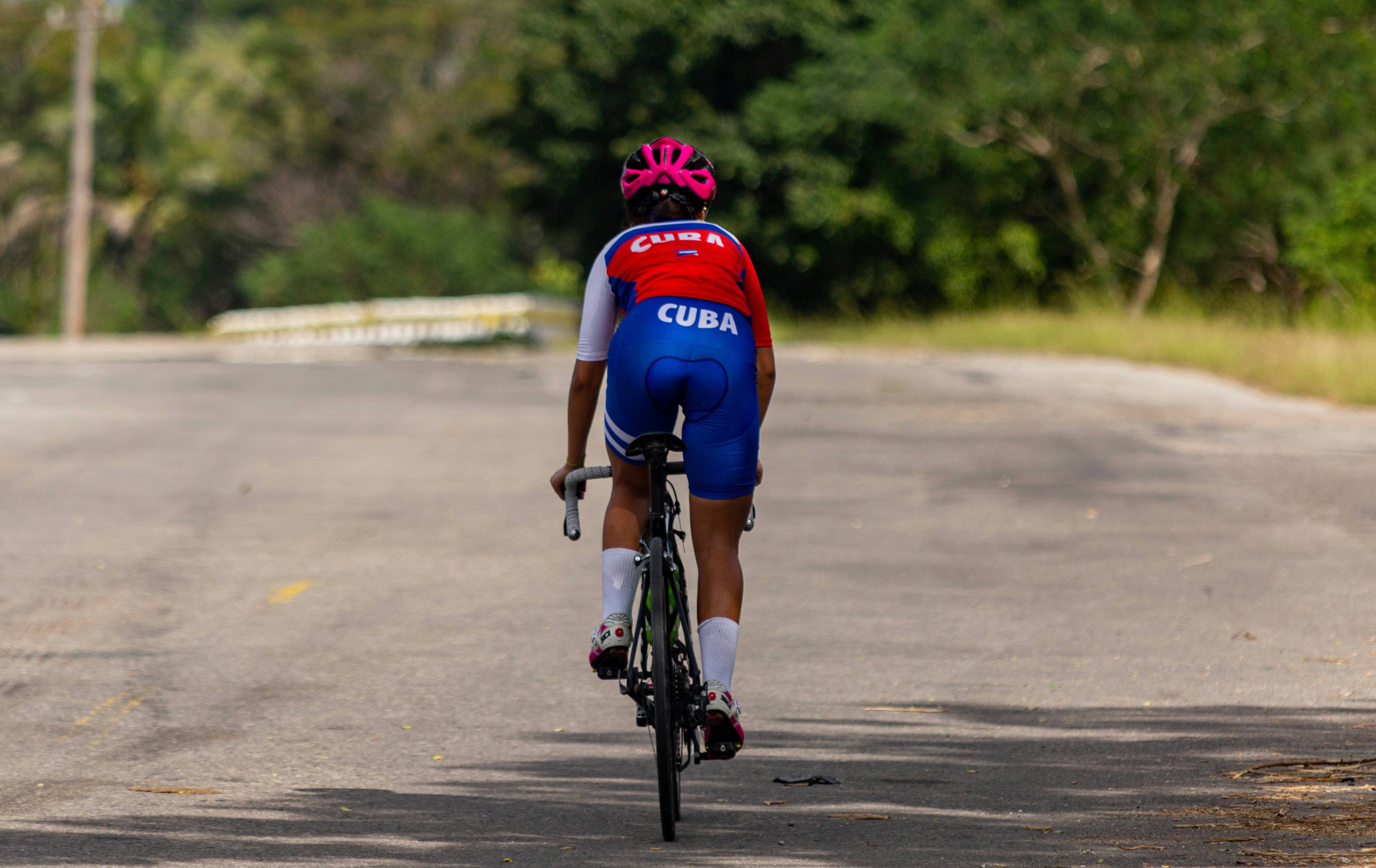 A man riding a bike down the middle of a road