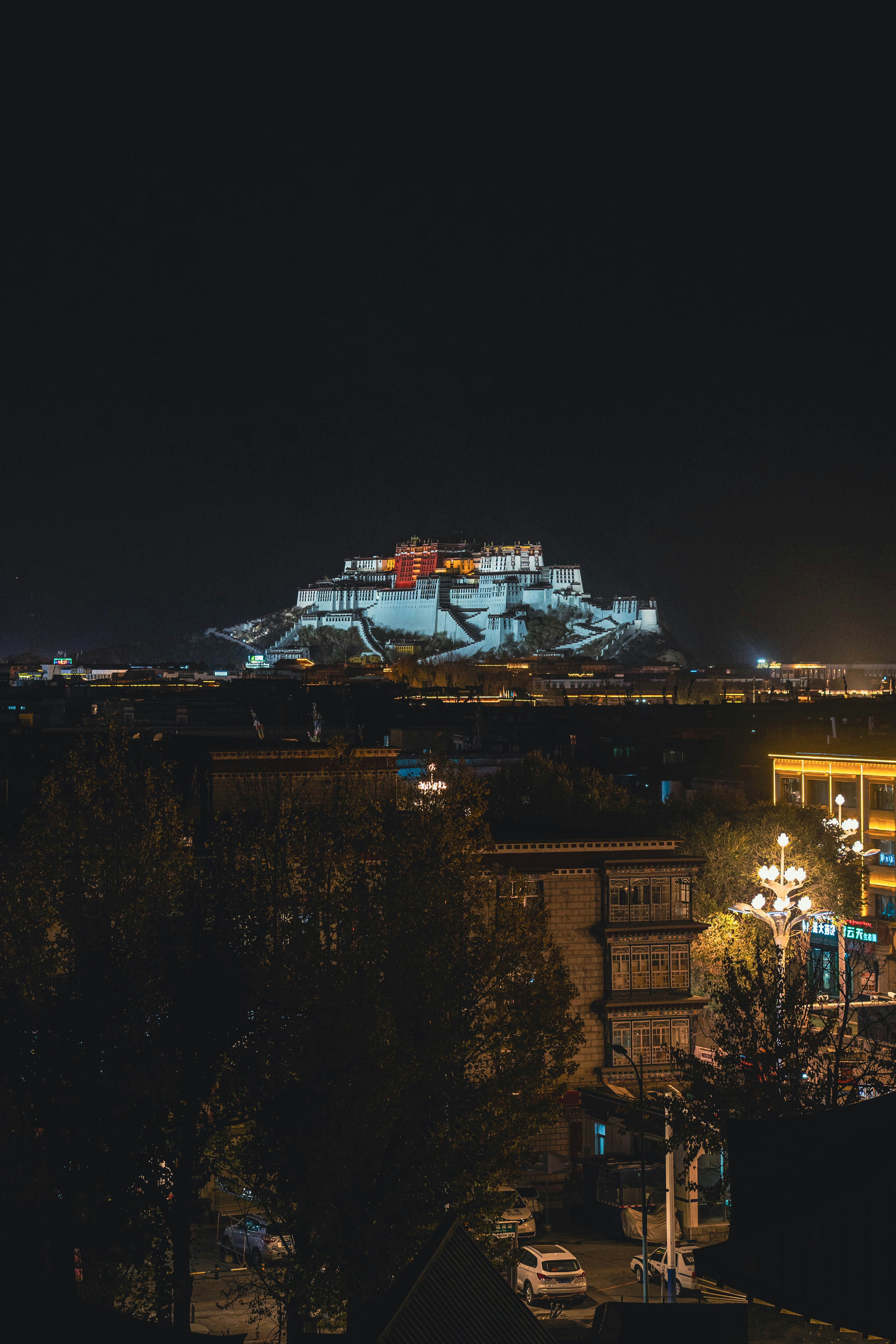 A night view of a city with a castle in the background