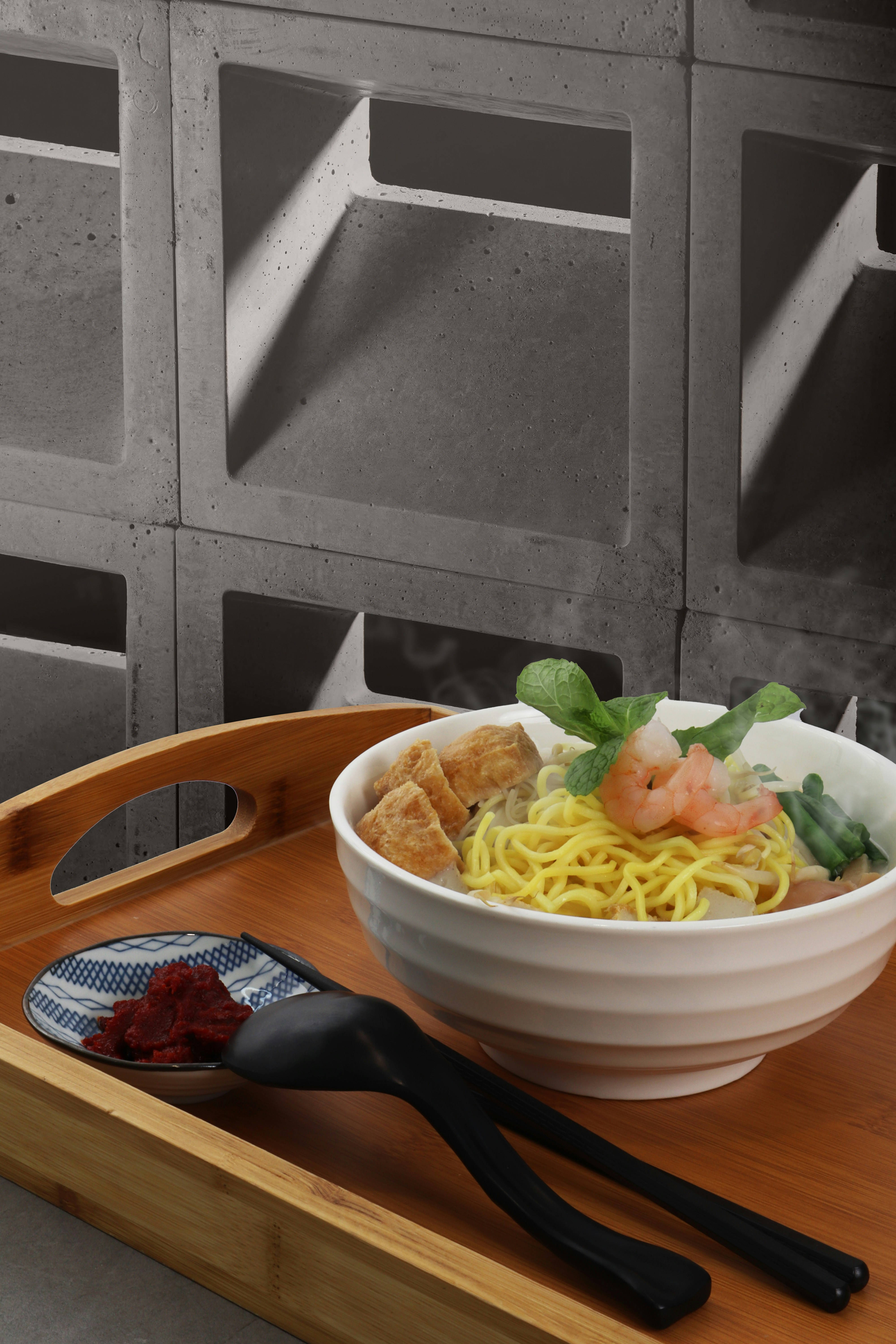 A wooden tray with a bowl of food on it