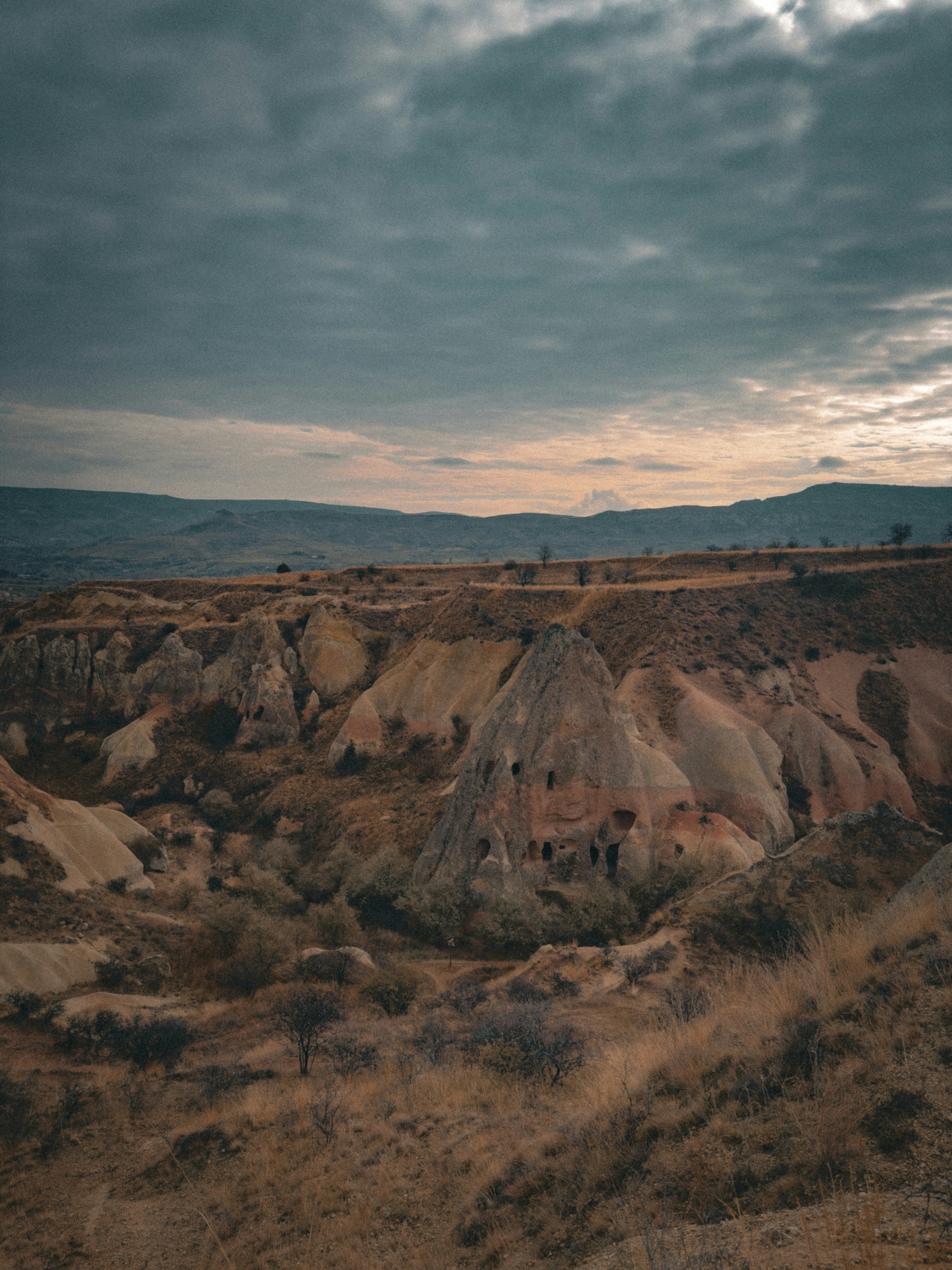 A view of a hill with a cloudy sky in the background