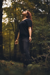 A woman standing in the middle of a forest